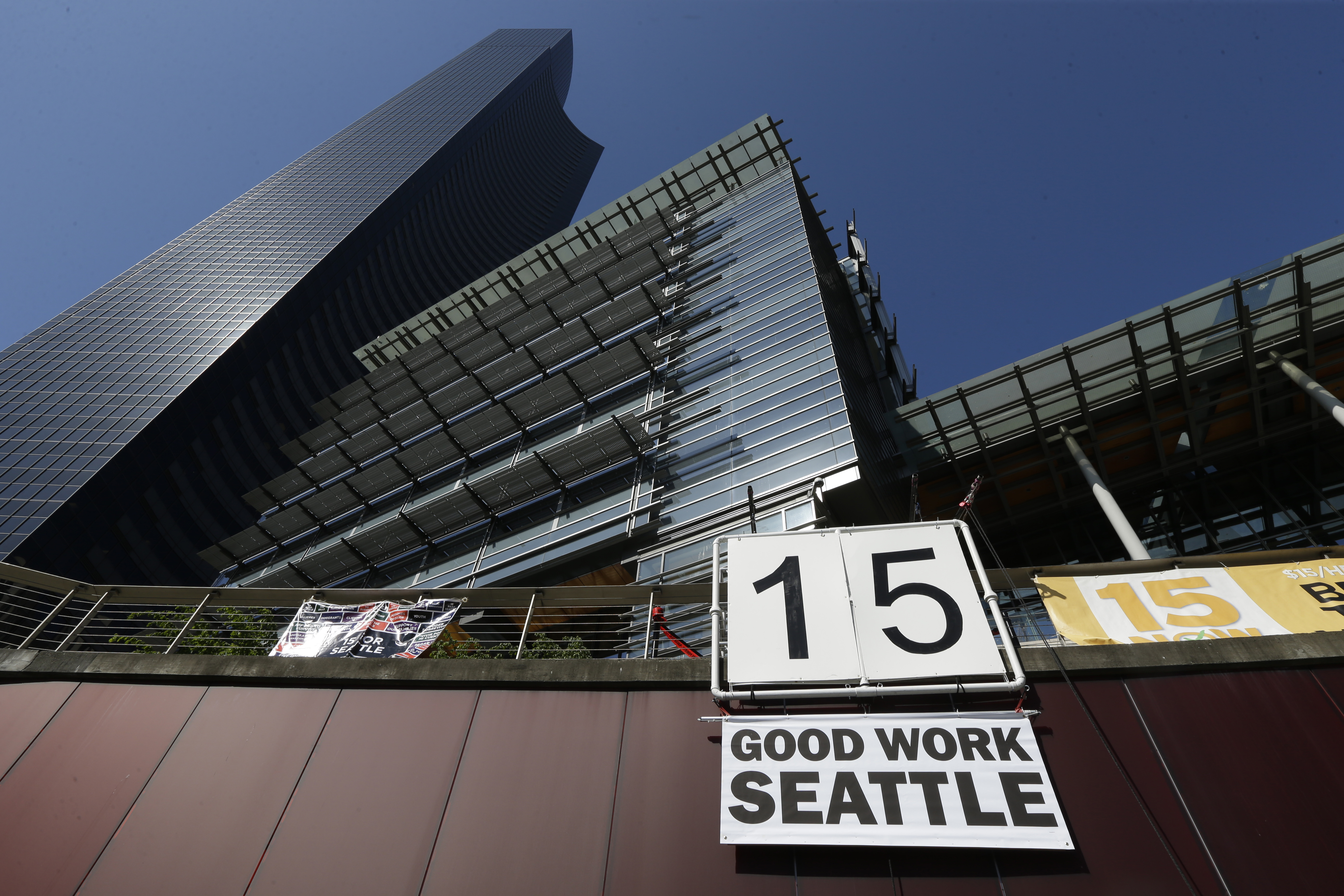 A sign that reads "15 Good Work Seattle" is displayed below Seattle City Hall, right, and the Columbia Center building, left, Monday, June 2, 2014, after the Seattle City Council passed a $15 minimum wage measure. (AP Photo/Ted S. Warren) (AP)