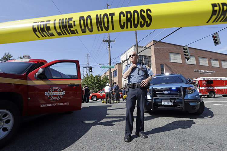 A police officer stands near the scene of a shooting on the campus of Seattle Pacific University Thursday, June 5, 2014, in Seattle. (AP/Elaine Thompson)