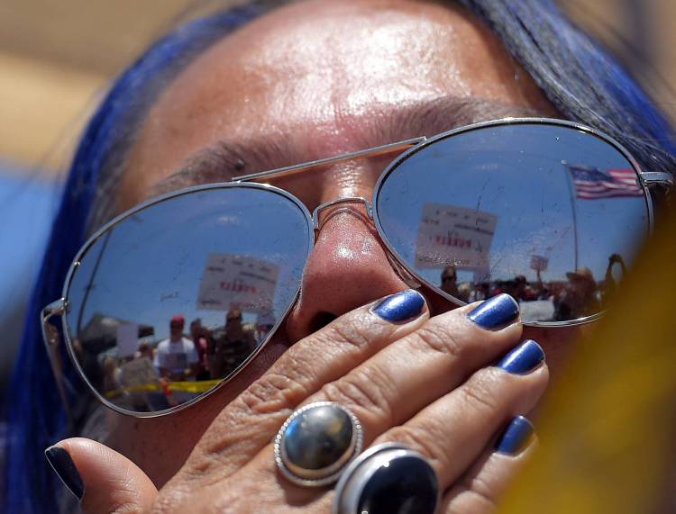 A pro-immigration demonstrator looks across a police line at the opposing side, Friday, July 4, 2014, outside a U.S. Border Patrol station in Murrieta, Calif. (Associated Press)