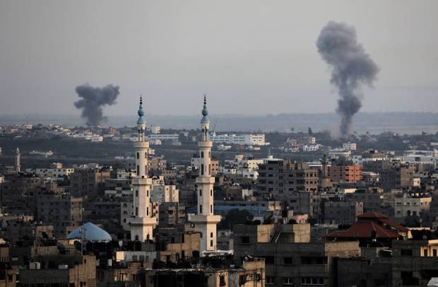 Columns of smoke rise following Israeli strikes on Gaza Strip, Saturday, July 12, 2014. Israeli airstrikes on Gaza hit a mosque and a center for the disabled where a few women were killed Saturday, raising the Palestinian death toll from the offensive to more than 130, Palestinian officials said, in an offensive that showed no signs of slowing down (AP Photo/Adel Hana)