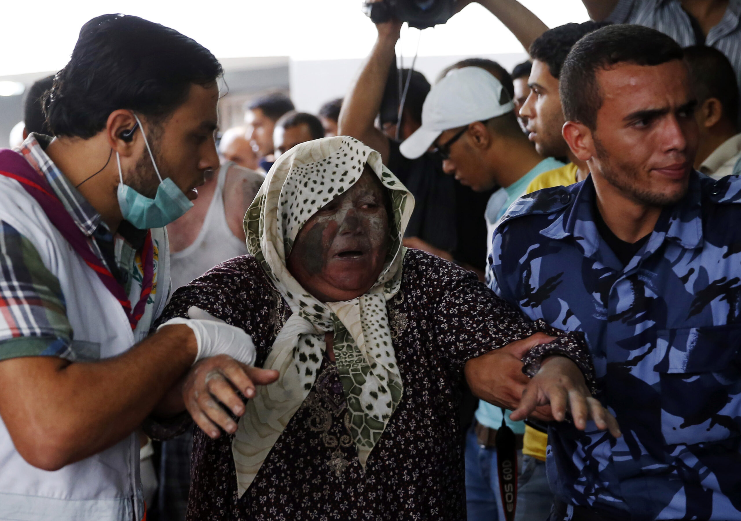 Palestinians escort a wounded woman in the emergency room of Shifa hospital in Gaza City, northern Gaza Strip, Sunday, July 20, 2014. Hundreds of panicked residents have fled a Gaza City neighborhood which they say has come under heavy tank fire from Israeli forces. Some reported seeing dead and wounded in the streets, with ambulances unable to reach the area. Israel widened its ground offensive early Sunday, sending more troops into the Hamas-ruled territory to destroy tunnels used by the Islamic militants to try to sneak into Israel. (AP Photo/Lefteris Pitarakis) (AP)