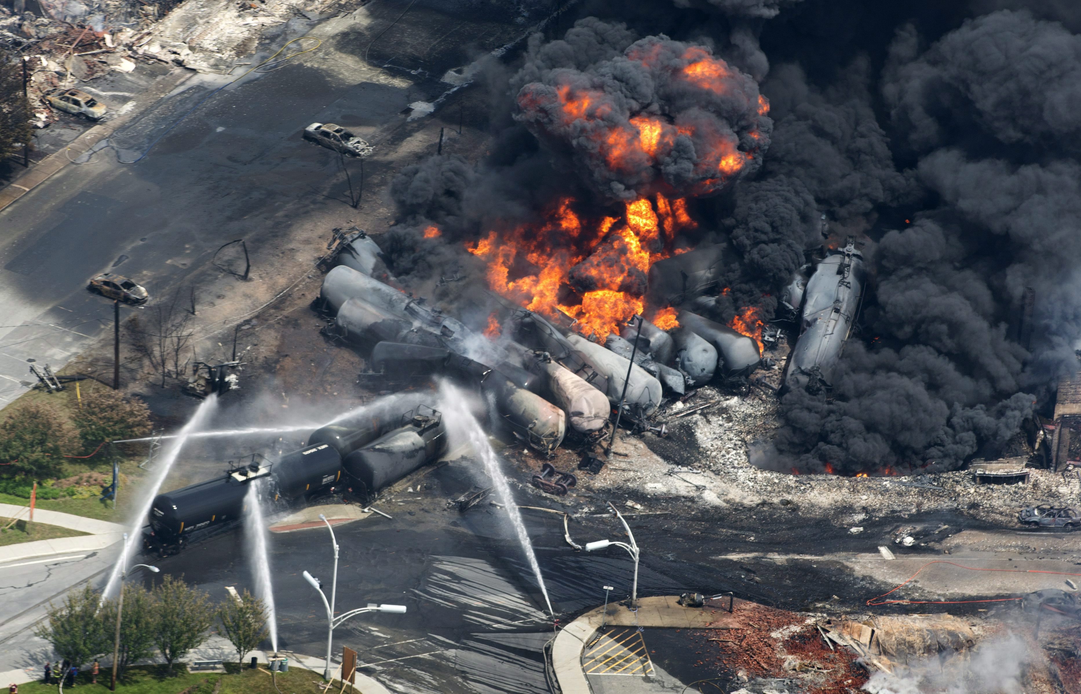 In this Saturday, July 6, 2013 photo, smoke rises from railway cars carrying crude oil after derailing in downtown Lac Megantic, Quebec. (AP Photo/The Canadian Press, Paul Chiasson) (AP)