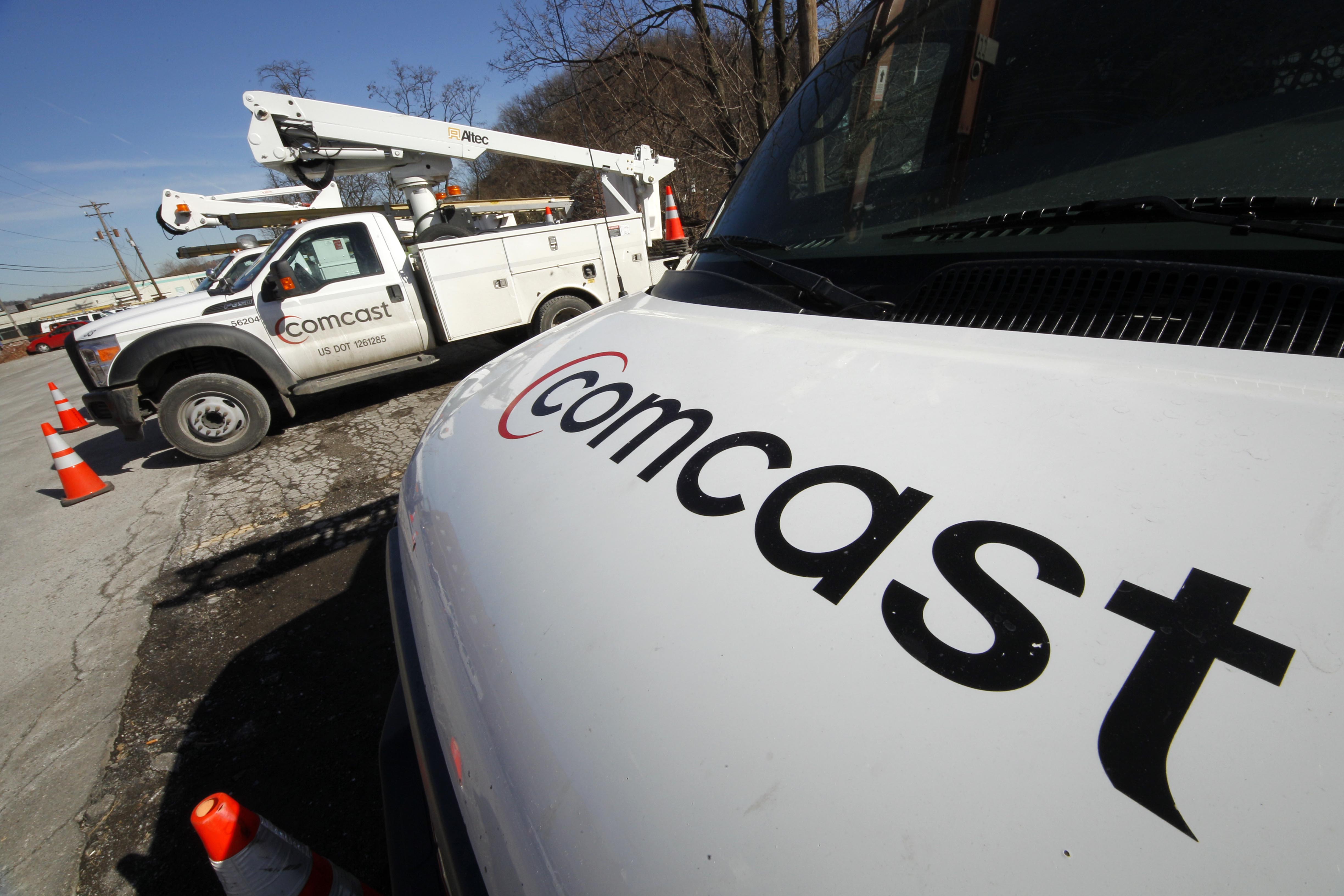 This Feb. 15, 2011 file photo shows Comcast installation trucks in Pittsburgh. (AP Photo/Gene J. Puskar, File)