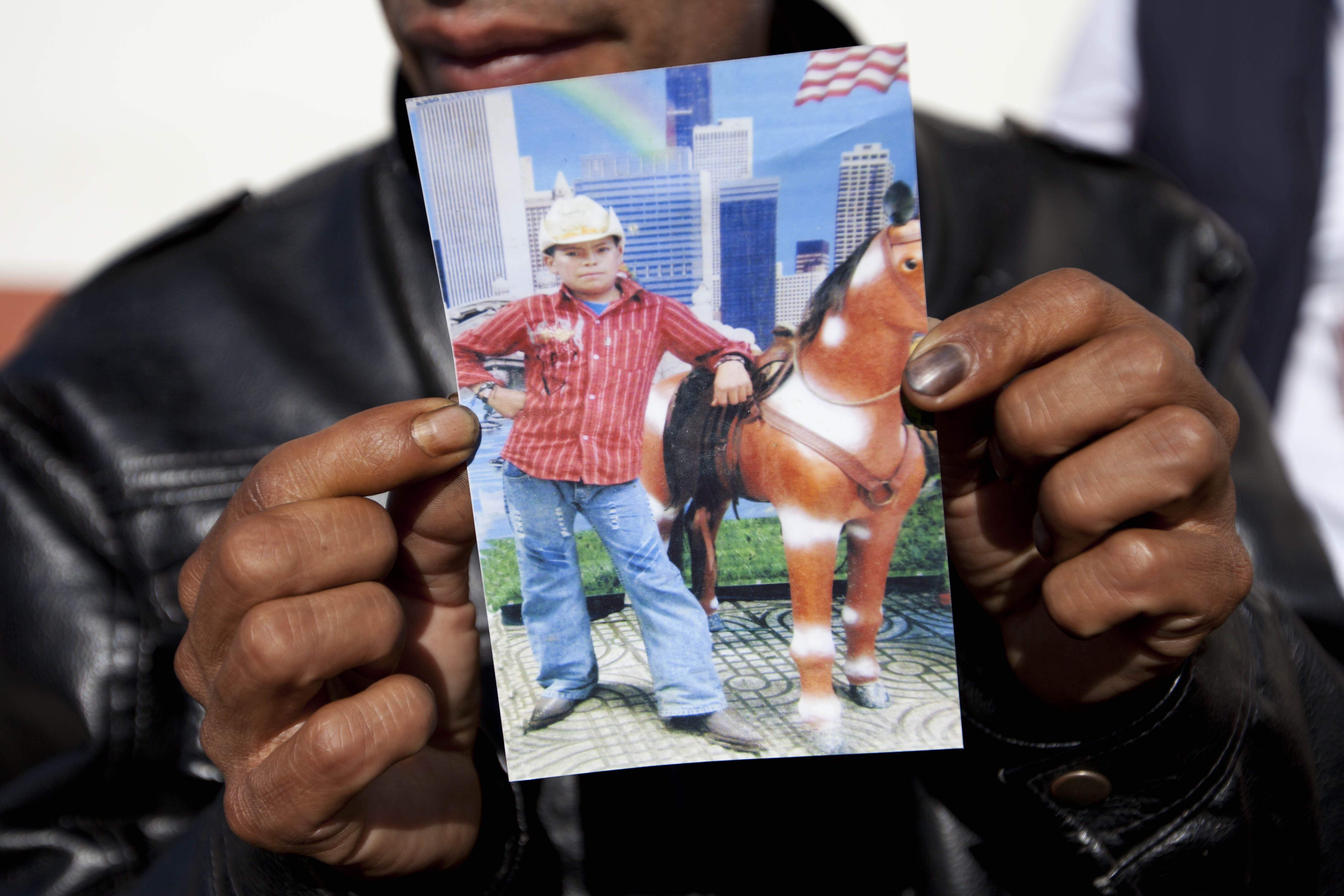 Francisco Ramos holds up a picture of his son, whose decomposed body was found in the Texas desert, as he waits for the arrival of his son's body, in Customs, in Guatemala City, Friday, July 11, 2014. The remains of Gilberto Francisco Ramos, the 15 year old boy who died in the Rio Grande Valley of South Texas, trying to reach the United States alone, was delivered to his family on Friday. (AP/Moises Castillo)