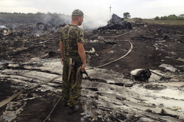 An armed pro-Russian separatist stands at a site of a Malaysia Airlines Boeing 777 plane crash in the settlement of Grabovo in the Donetsk region, July 17, 2014. (Reuters/Maxim Zmeyev)