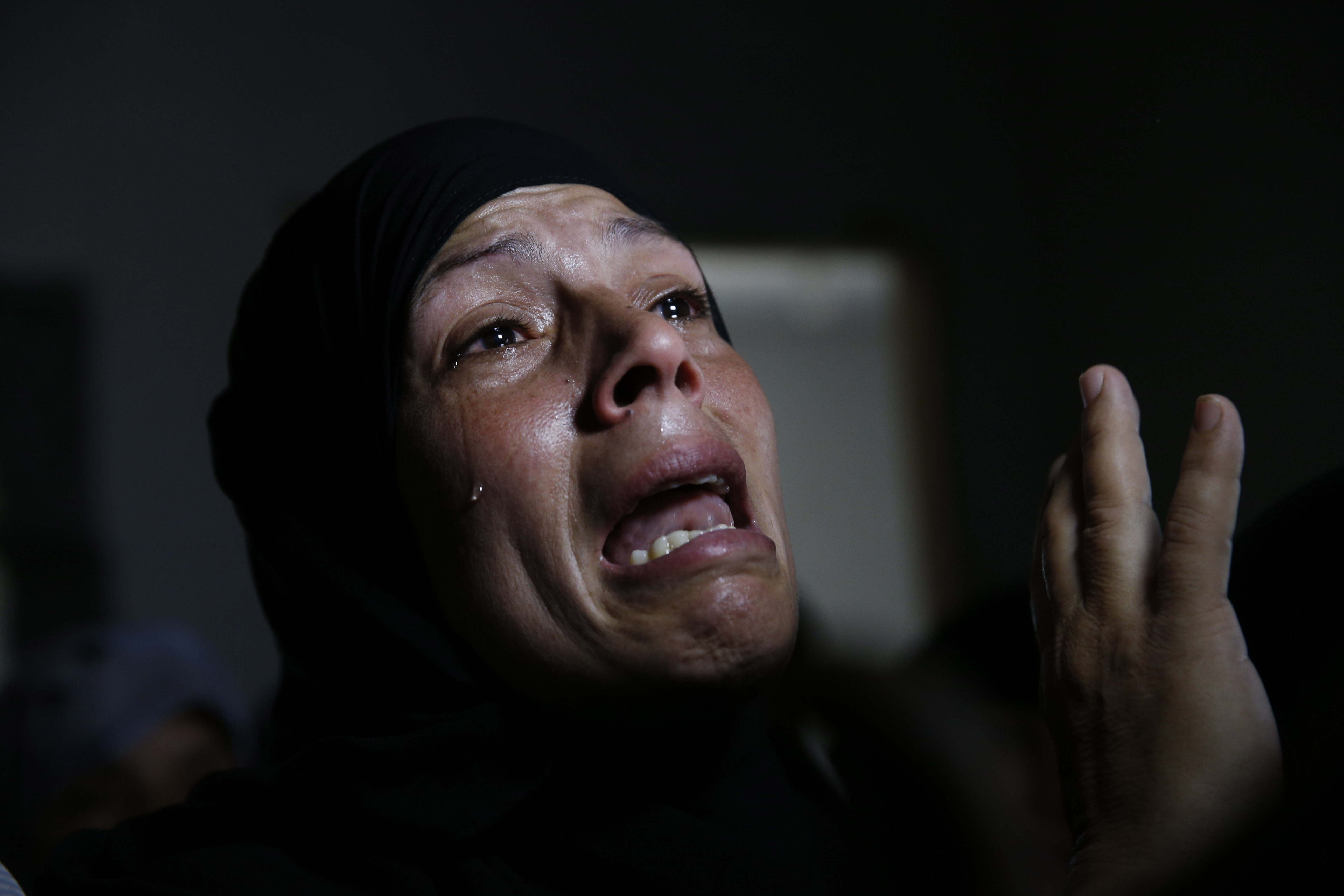 A Palestinian mourner cries in a house after the bodies of Mousa Abu Muamer, 56, and his son Saddam, 27, who were killed in an overnight Israeli missile strike at their house in the outskirts of the town of Khan Younis, southern Gaza Strip, were brought in for their funeral, Monday, July 14, 2014. Saddam's wife, Hanadi, 27, was also killed in the attack. (AP Photo/Lefteris Pitarakis) (AP)