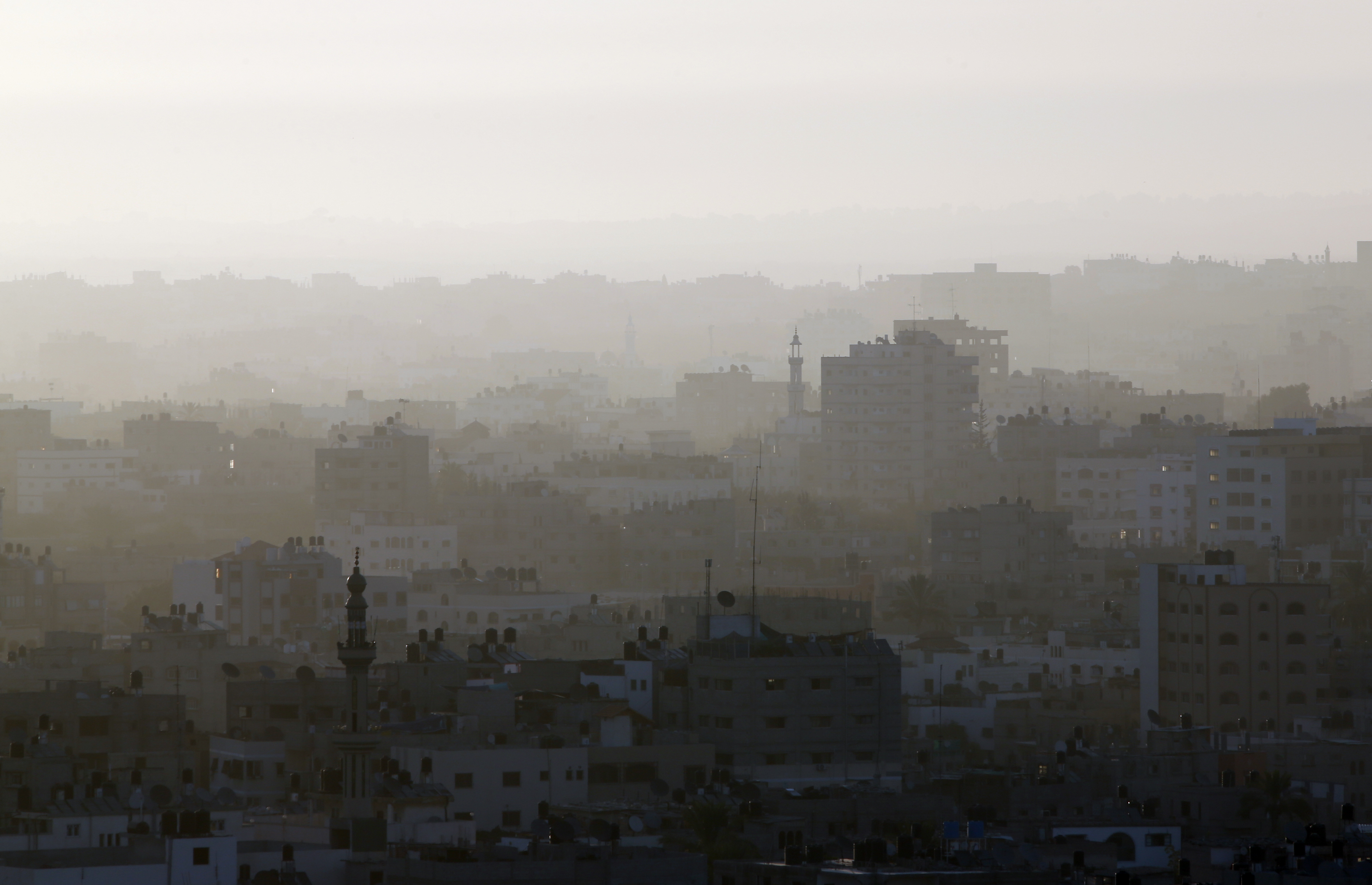 A hazy Gaza City is seeen in northern Gaza strip early Friday, July 18, 2014. The heavy thud of tank shells, often just seconds apart, echoed across the Gaza Strip early Friday as thousands of Israeli soldiers launched a ground invasion, escalating a 10-day campaign of heavy air bombardments to try to destroy Hamas' rocket-firing abilities and the tunnels militants use to infiltrate Israel. (AP Photo/Lefteris Pitarakis) (AP)