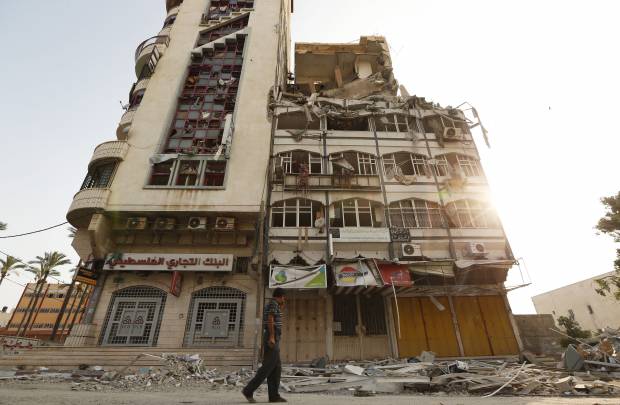 A Palestinian inspects the damage of the Al-Shalam (Peace) tower, destroyed by an overnight Israeli strike. (AP Photo/Lefteris Pitarakis)