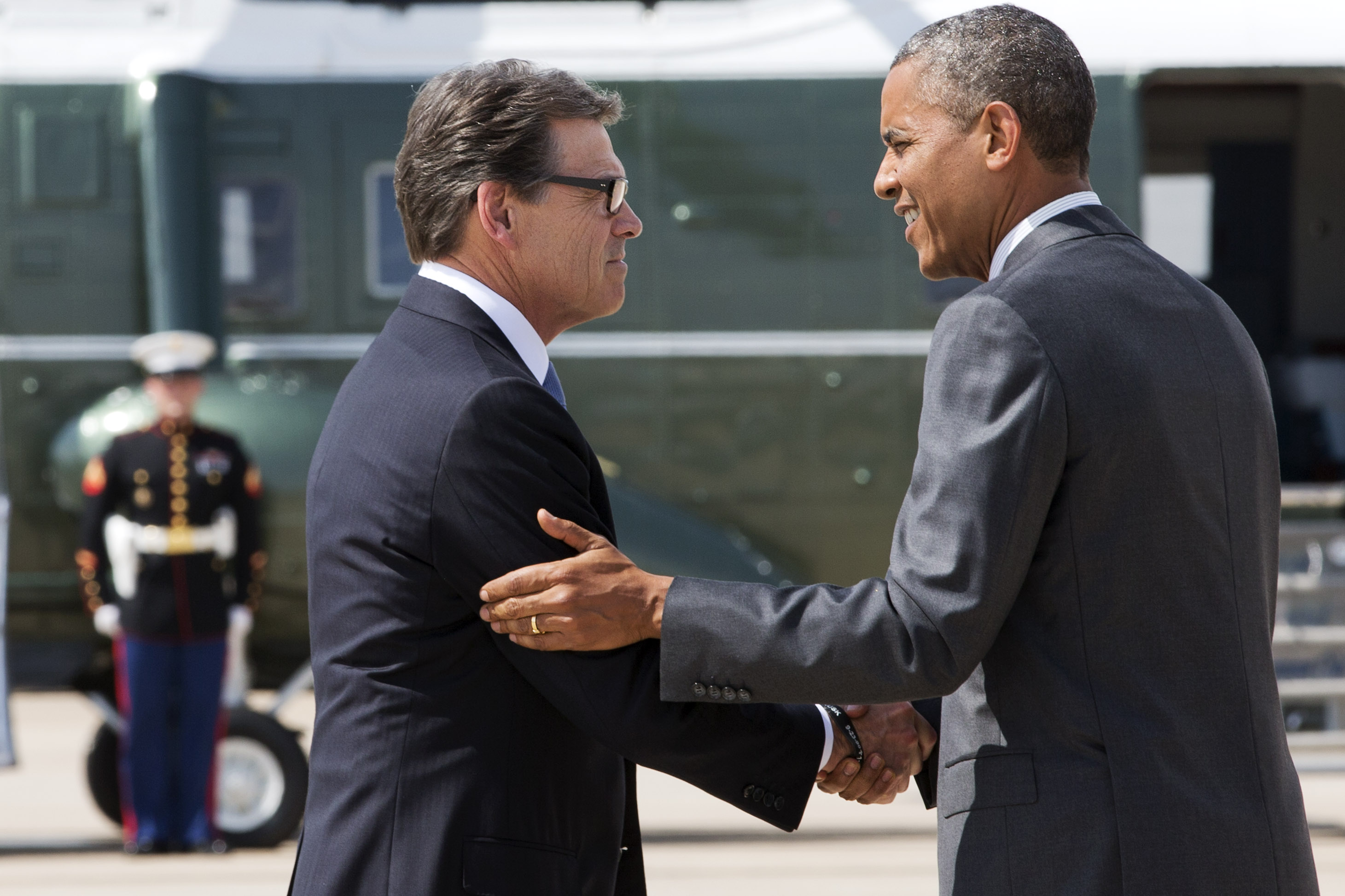 President Barack Obama, right, and Texas Gov. Rick Perry shake hands as Obama arrives in Dallas where they will attend a meeting about the border and immigration together, Wednesday, July 9, 2014. (AP Photo/Jacquelyn Martin) (AP)