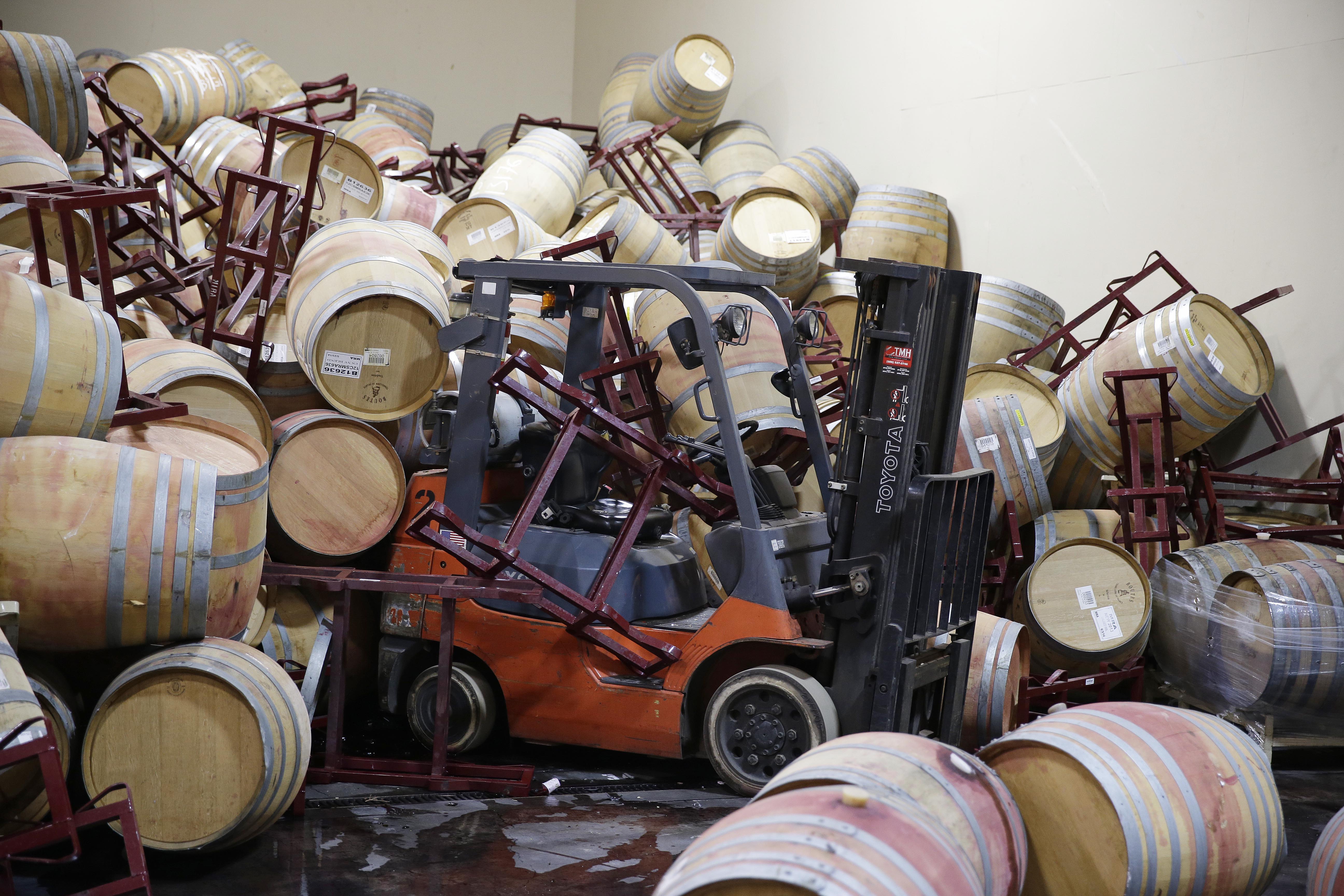 A forklift is partially buried in some of the hundreds of earthquake damaged wine barrels at the Kieu Hoang Winery Monday, Aug. 25, 2014, in Napa, Calif. A powerful earthquake that struck the heart of California's wine country caught many people sound asleep, sending dressers, mirrors and pictures crashing down around them and toppling wine bottles in vineyards around the region. The magnitude-6.0 quake struck at 3:20 a.m. PDT Sunday near the city of Napa. (AP Photo/Eric Risberg) (AP)
