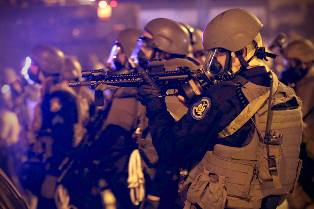 Police advance after tear gas was used to disperse a crowd Sunday, Aug. 17, 2014,  in Ferguson, Mo. (AP/Charlie Riedel)