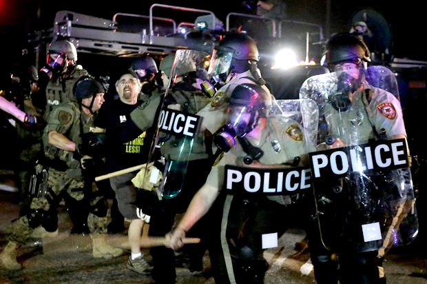 A man is detained after a standoff between protesters and police Monday, Aug. 18, 2014, in Ferguson, Mo. (AP/Charlie Riedel)