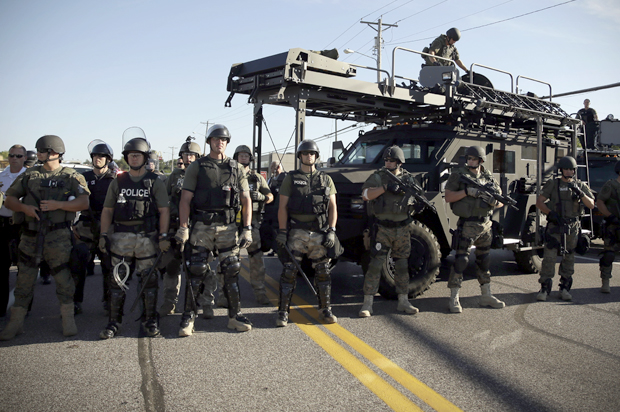 Police in riot gear watch protesters in Ferguson, Mo., Aug. 13, 2014. (AP/Jeff Roberson)