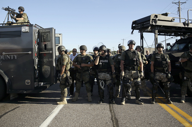 Police in riot gear watch protesters in Ferguson, Mo., Aug. 13, 2014. (AP/Jeff Roberson)