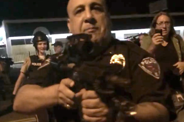 An officer points his rifle at the crowd in Ferguson. (YouTube/Caleb-Michael Files)