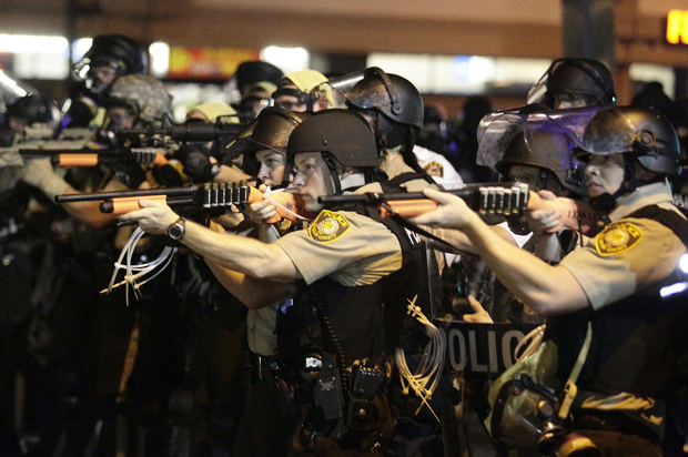 Police officers point their weapons at demonstrators in Ferguson, Missouri, August 18, 2014. (Reuters/Joshua Lott)
