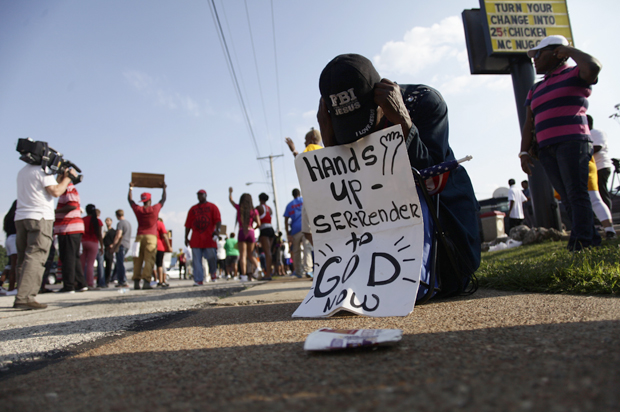 A demonstrator kneels and prays during a protest against the shooting death of Michael Brown in Ferguson, Missouri August 18, 2014. (Reuters/Joshua Lott)