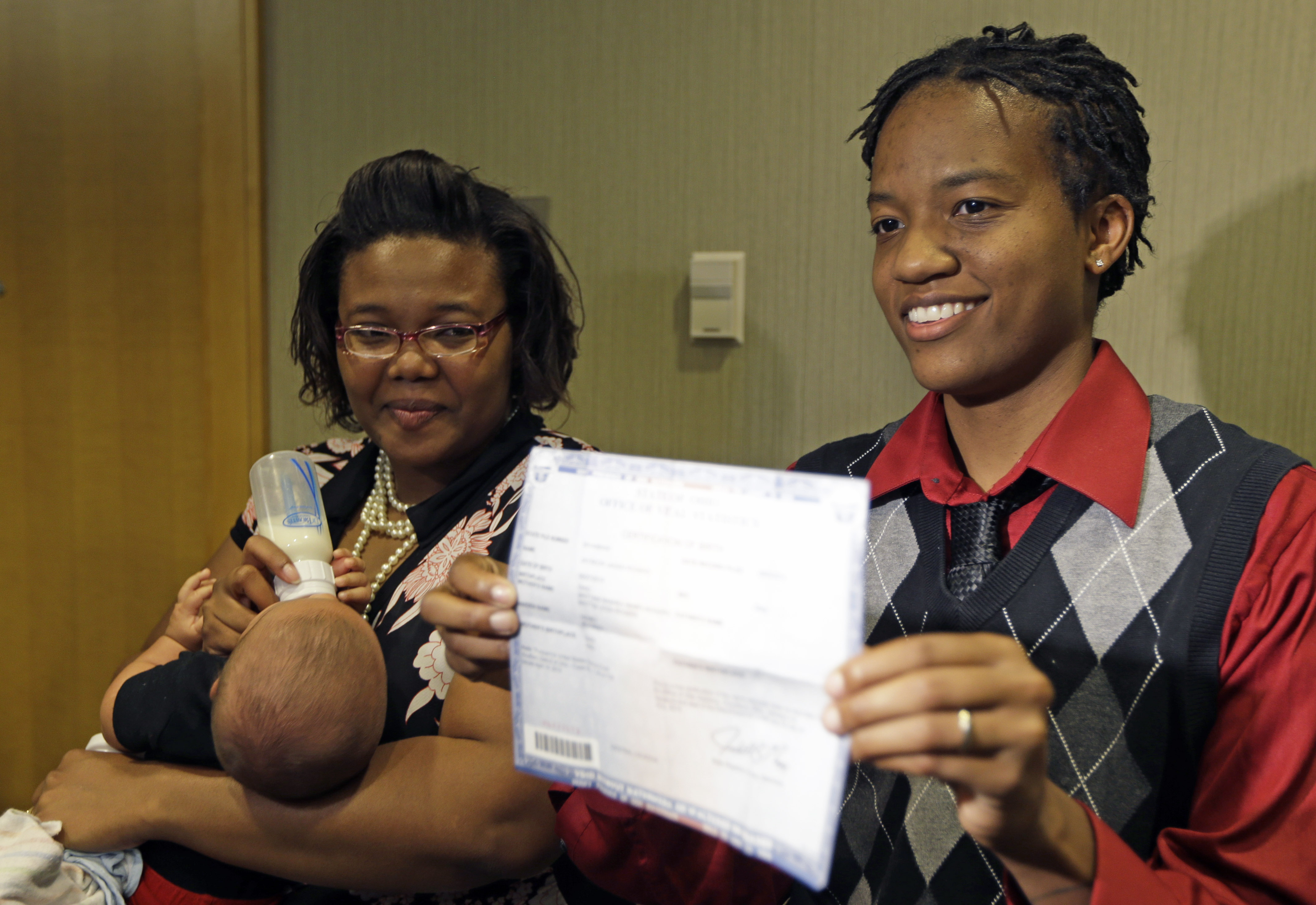 Kelly Noe, right, stands with her partner Kelly McCracken, as Noe holds a birth certificate for their daughter that has both of their names on it, Wednesday, Aug. 6, 2014, in Cincinnati. The couple are plaintiffs in the Ohio gay marriage case heard Wednesday in Cincinnati. A three judge panel of the 6th U.S. Circuit Court of Appeals heard arguments in six gay marriage fights from four states, Kentucky, Michigan, Ohio and Tennessee. (AP Photo/Al Behrman) (AP)