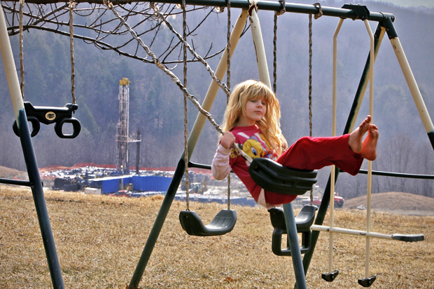 Rachel Farnelli rides on her backyard swing that overlooks the Gesford #3 natural gas well in Dimock, Pennsylvania, March 7, 2009. (Reuters/Tim Shaffer)