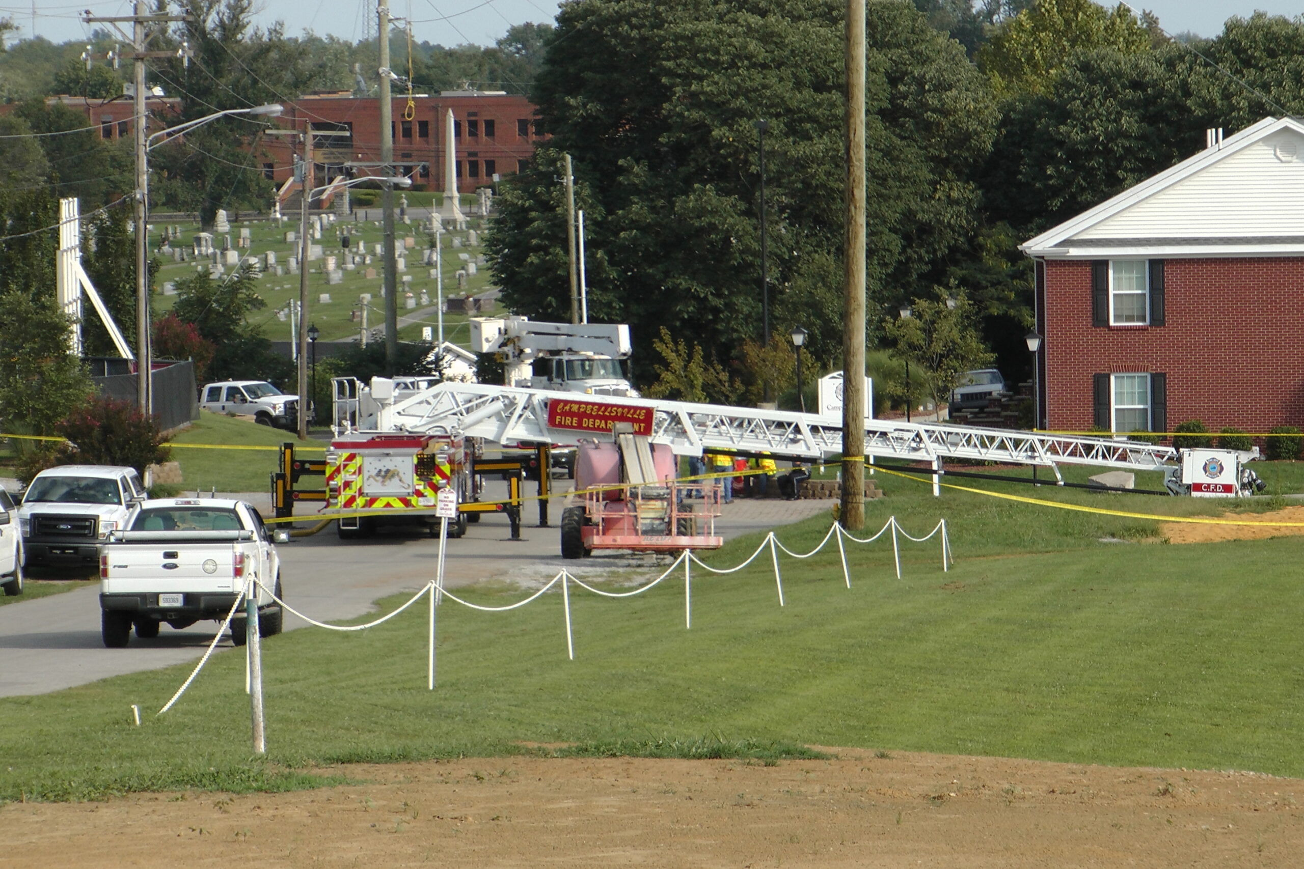 A Campbellsville Fire Department truck with the ladder extended remained at the scene where two firefighters were injured during an ice bucket challenge during a fundraiser for ALS on Thursday, Aug. 21, 2014, in Campbellsville, Ky. Officials say the ladder got too close to a power line and electricity traveled to the ladder, electrocuting the firefighters. (AP Photo/Dylan Lovan) (AP)