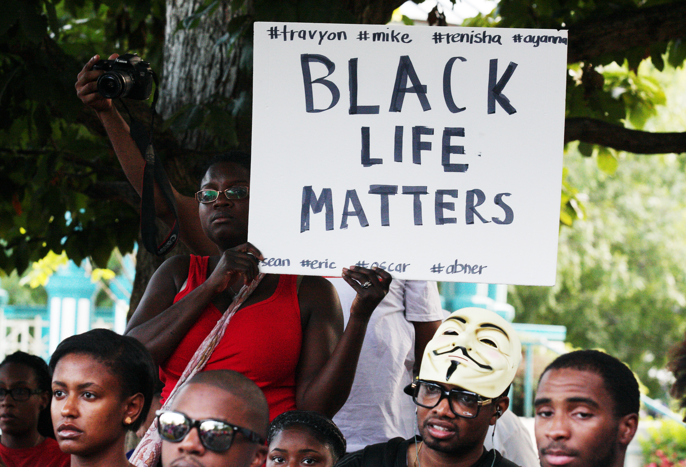 People in a crowd hold signs and listen to speakers at a demonstration on Thursday, Aug. 14, 2014, in Decatur, Georgia, in the town square. The demonstration of more than 200 people was held in response to the shooting death of Michael Brown and following unrest in Ferguson, Missouri. (AP Photo/ Ron Harris) (Ron Harris)