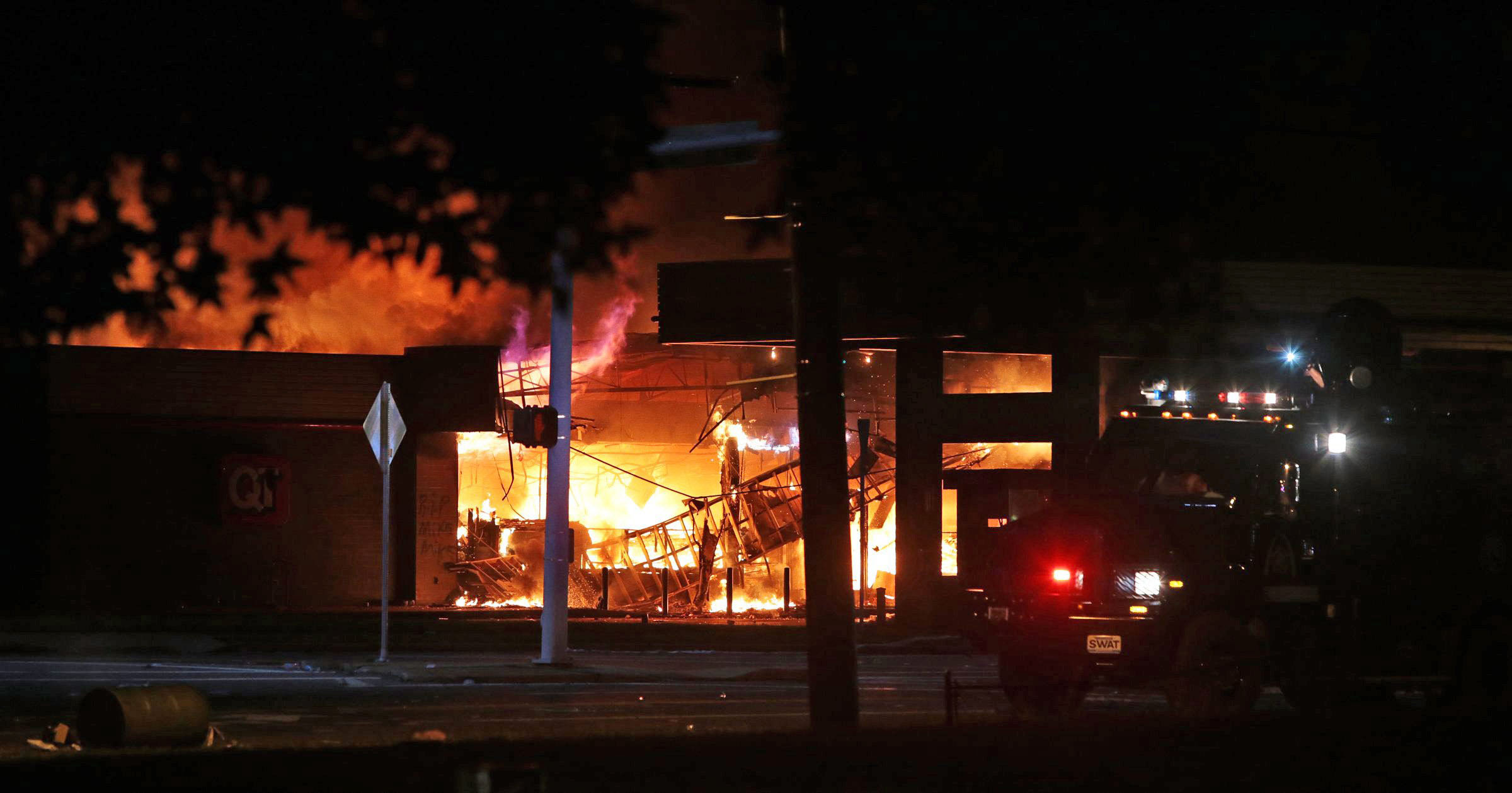 A fire is seen Sunday, Aug. 10, 2014, in Ferguson, Mo. A few thousand people crammed a suburban St. Louis street Sunday night at a vigil for unarmed 18-year-old Michael Brown shot and killed by a police officer, while afterward several car windows were smashed and stores were looted as people carried away armloads of goods as witnessed by an an Associated Press reporter. Video posted online by the St. Louis Post-Dispatch showed a convenience store on fire. (AP Photo/St. Louis Post-Dispatch, Robert Cohen) (AP)
