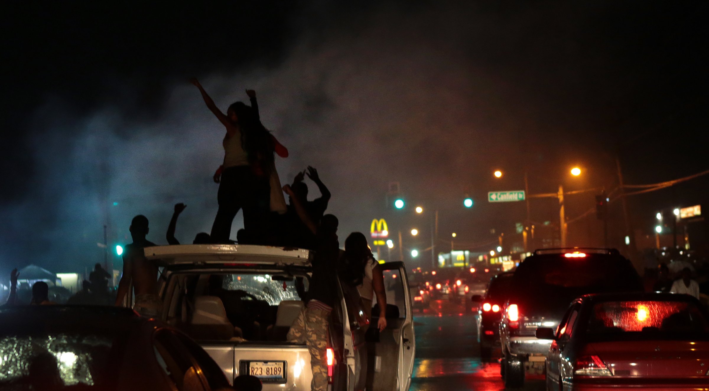 Smoke from a tire burnout rises over protestors on West Florissant Avenue in Ferguson on Friday, Aug. 15, 2014.   (AP Photo/St. Louis Post-Dispatch, Robert Cohen) (AP)