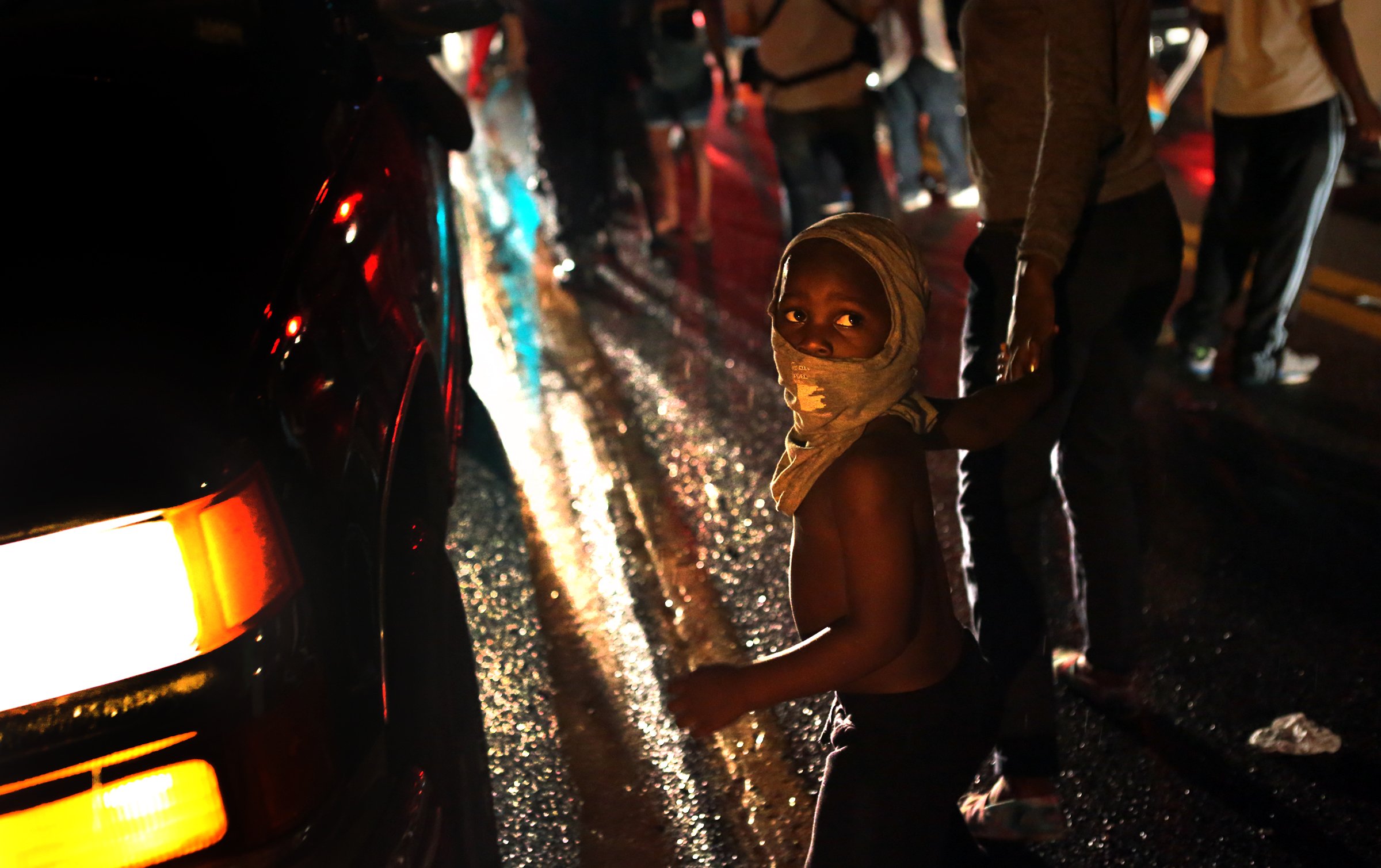 Isaiah King Ivy, 3, makes his shirt a mask as he participates in demonstrations with his north St. Louis County family on West Florissant Avenue in Ferguson on Friday, Aug. 15, 2014.  (AP Photo/St. Louis Post-Dispatch, Robert Cohen) (AP)