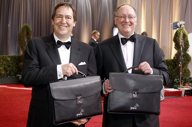 The results of the Academy Awards balloting are carried up the red carpet by Price Waterhouse Coopers accountants Rick Rosas and Brad Oltmans, February 26, 2012. (Reuters/Lucas Jackson)