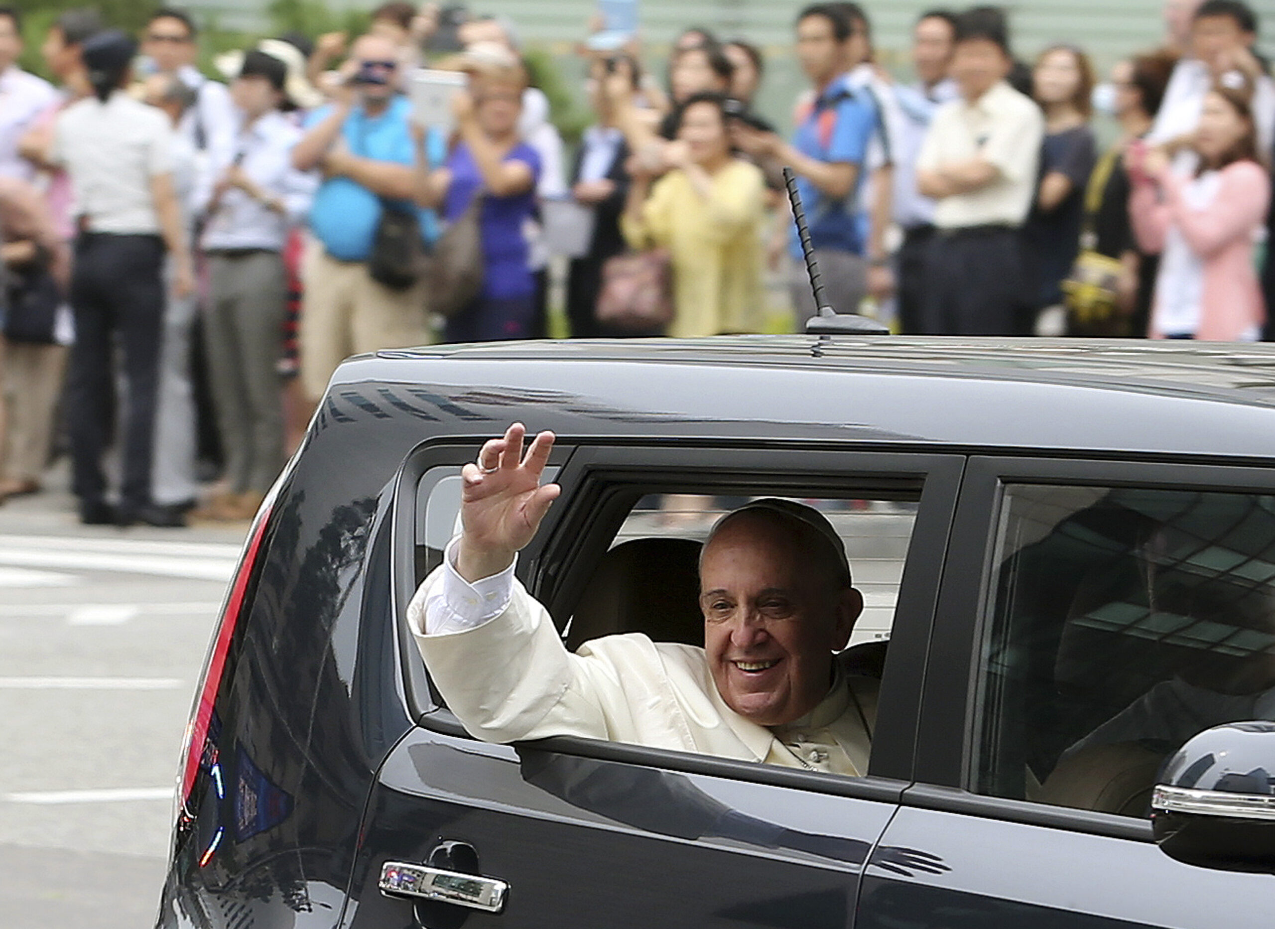 Pope Francis waves from a car after his arrival in Seoul, South Korea, Thursday, Aug. 14, 2014. As Francis became the first pope in 25 years to visit South Korea on Thursday, Seoul's never-timid rival, North Korea, made its presence felt by firing three short-range projectiles less than an hour before he arrived, officials said. (AP Photo/Yonhap, Lim Hun-jung) KOREA OUT (Lim Hun-jung)
