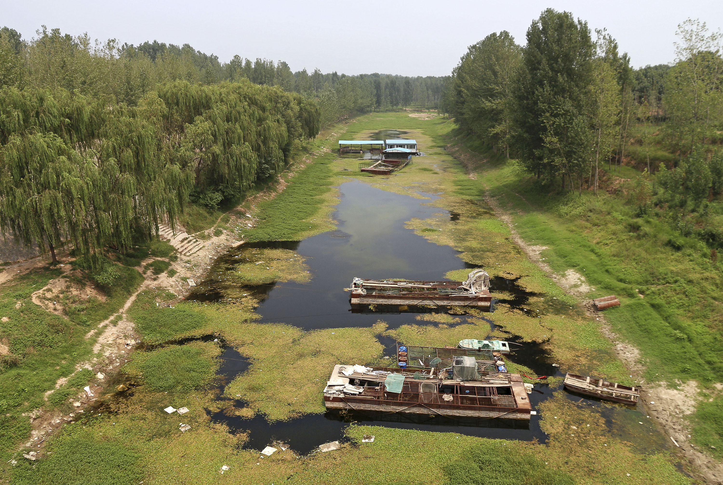 In this Monday, July 28, 2014 photo, boats sit on a dried river bed in Xunxian county in central China's Henan province. After a season of record-breaking drought across China, groundwater levels have hit historic lows this year in northeast and central parts of China where hundreds of millions of people live. Reservoirs grew so dry in agricultural Henan province that the city of Pingdingshan closed car washes and bathhouses and extracted water from puddles. (AP Photo) CHINA OUT (AP)