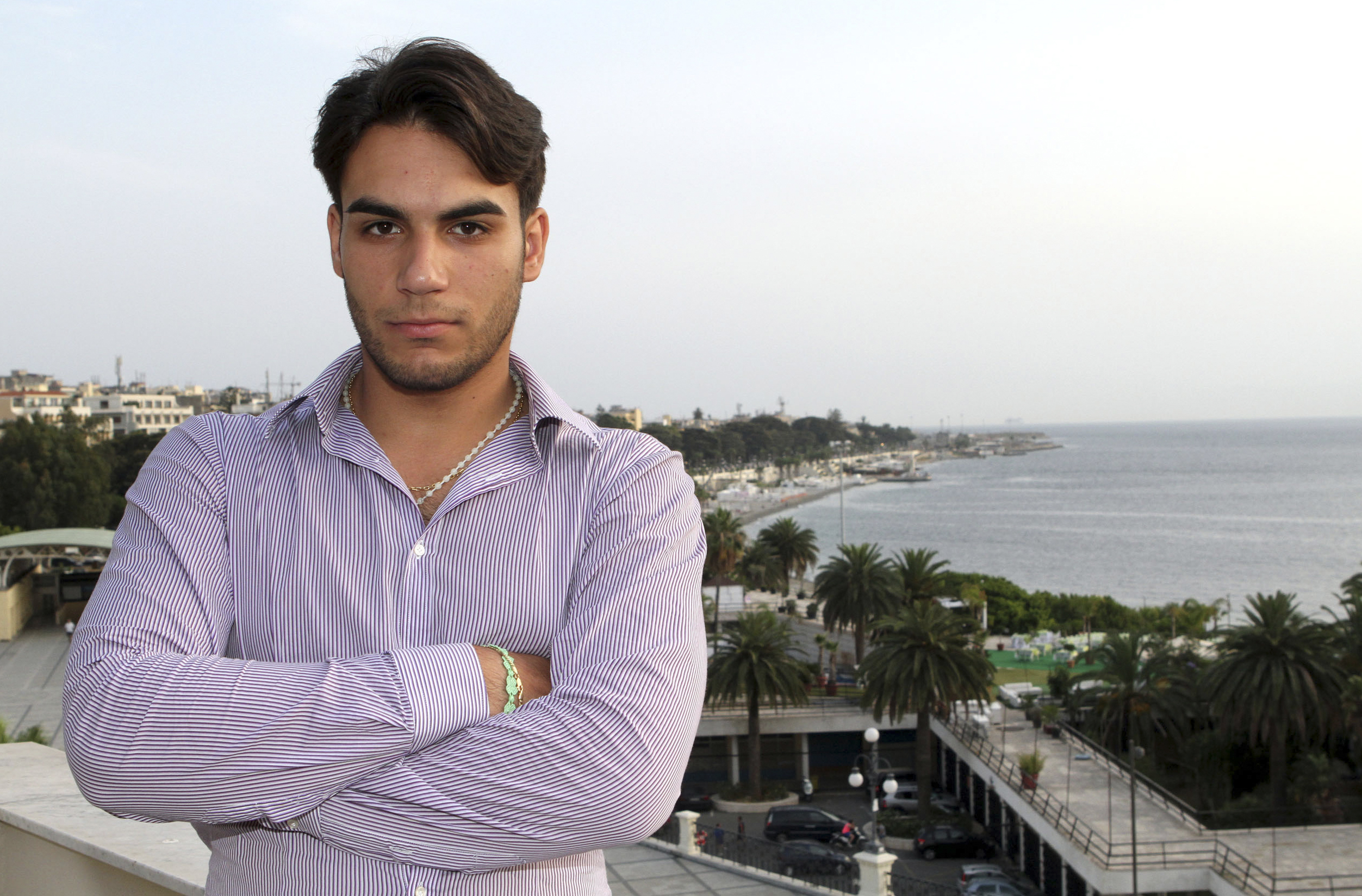 In this June 26, 2014 photo, Riccardo Cordi' stands on a terrace in Reggio, Calabria Italy with the Strait of Messina in the background. Cordi' was exiled to Messina during a pioneering anti-mafia program for juveniles, a kind of rehab away from the mob. (AP Photo/Adriana Sapone) (AP)
