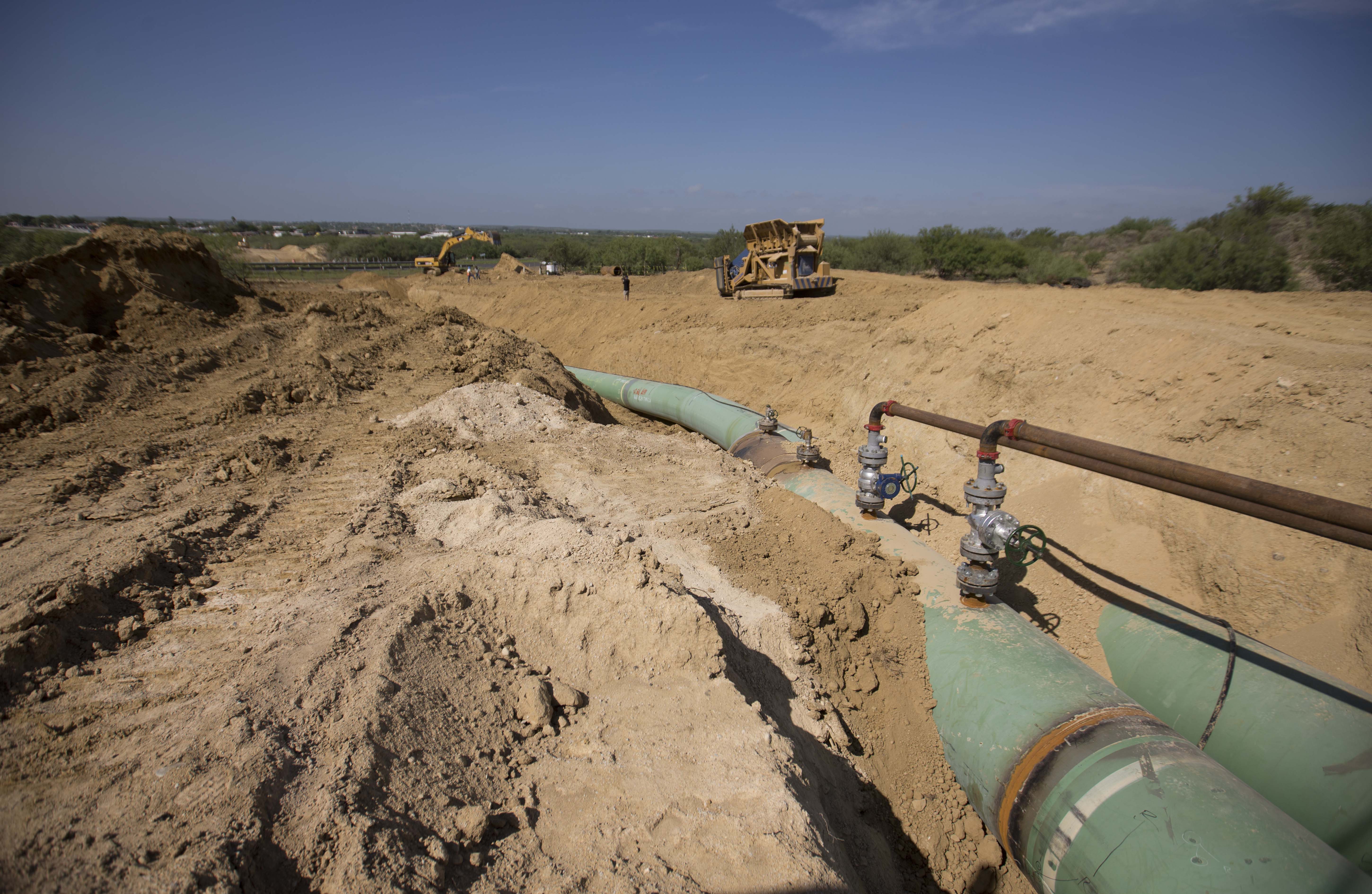 In this Sept. 7, 2014 photo, new pipelines that will carry gas from Texas to Mexico, eventually reaching the city of Guanajuato, are laid underground near General Bravo, in Nuevo Leon state, Mexico. So far this year, thieves across Mexico have drilled so many illegal taps into state-owned pipelines, siphoning off  gas and oil, that they're on pace to set a new annual record. (AP Photo/Eduardo Verdugo) (AP)