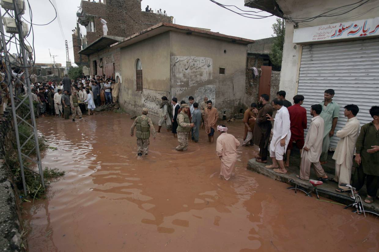 Pakistani army troops rescue local residents from a flooded area caused by heavy rains on the outskirts of Islamabad, Pakistan, Friday, Sept. 5, 2014. Heavy monsoon rains killed dozens of people across Pakistan as flash flood inundated villages, prompting authorities to send troops to evacuate residents and assist in the emergency, officials said. (AP/Anjum Naveed)