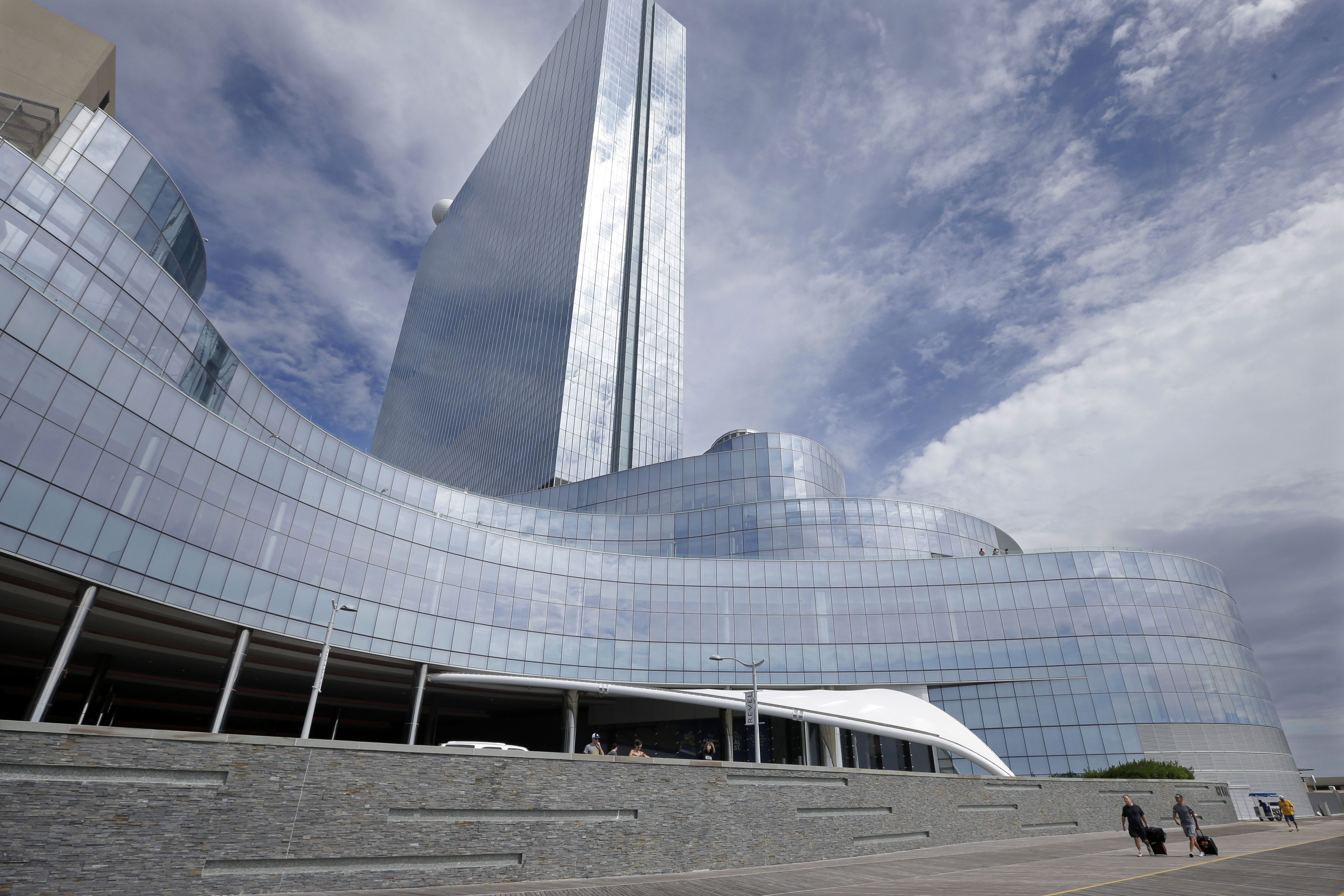 FILE - In this Sept. 1, 2014, file photo, Randy Chapman, left, of California, and John Krisel, of New York, walk on The Boardwalk after they checked out of the closing Revel Casino Hotel in Atlantic City, N.J. A bankruptcy court auction for Revel, the failed luxury casino-hotel on the Atlantic City Boardwalk, will resume on Tuesday, Sept. 30, 2014. (AP Photo/Mel Evans, File) (AP)