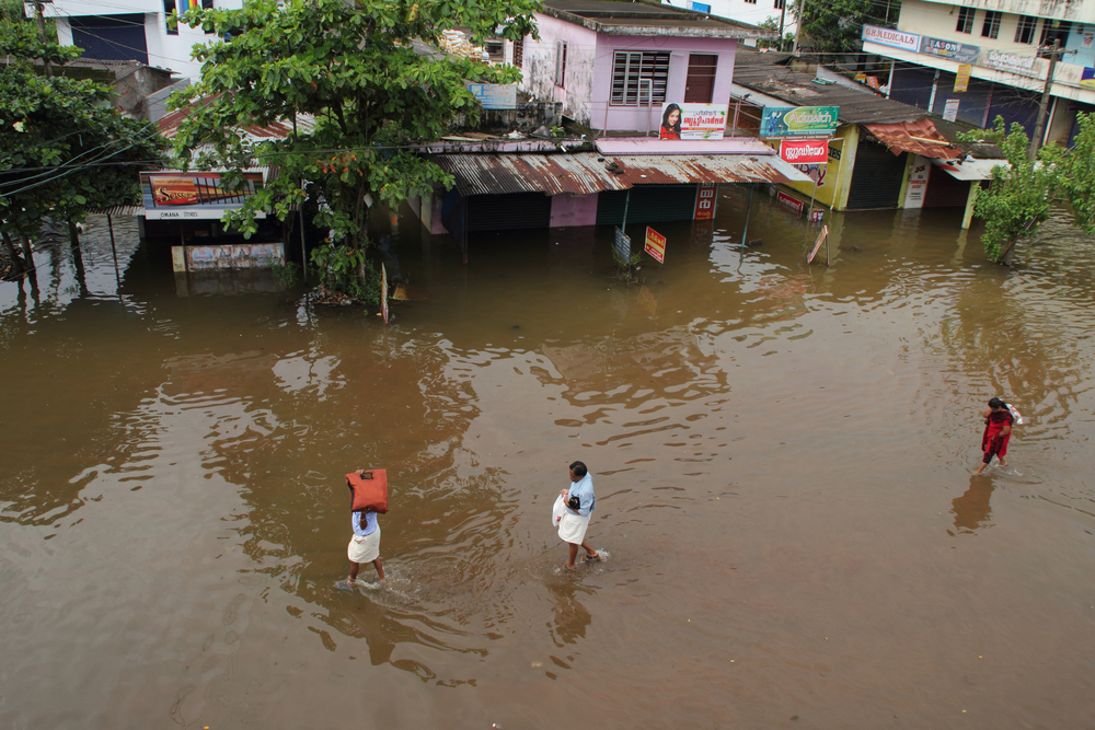 Unidentified people walk on the flood water on June 26,2013 in Kuttanad, India. (AJP/Shutterstock)