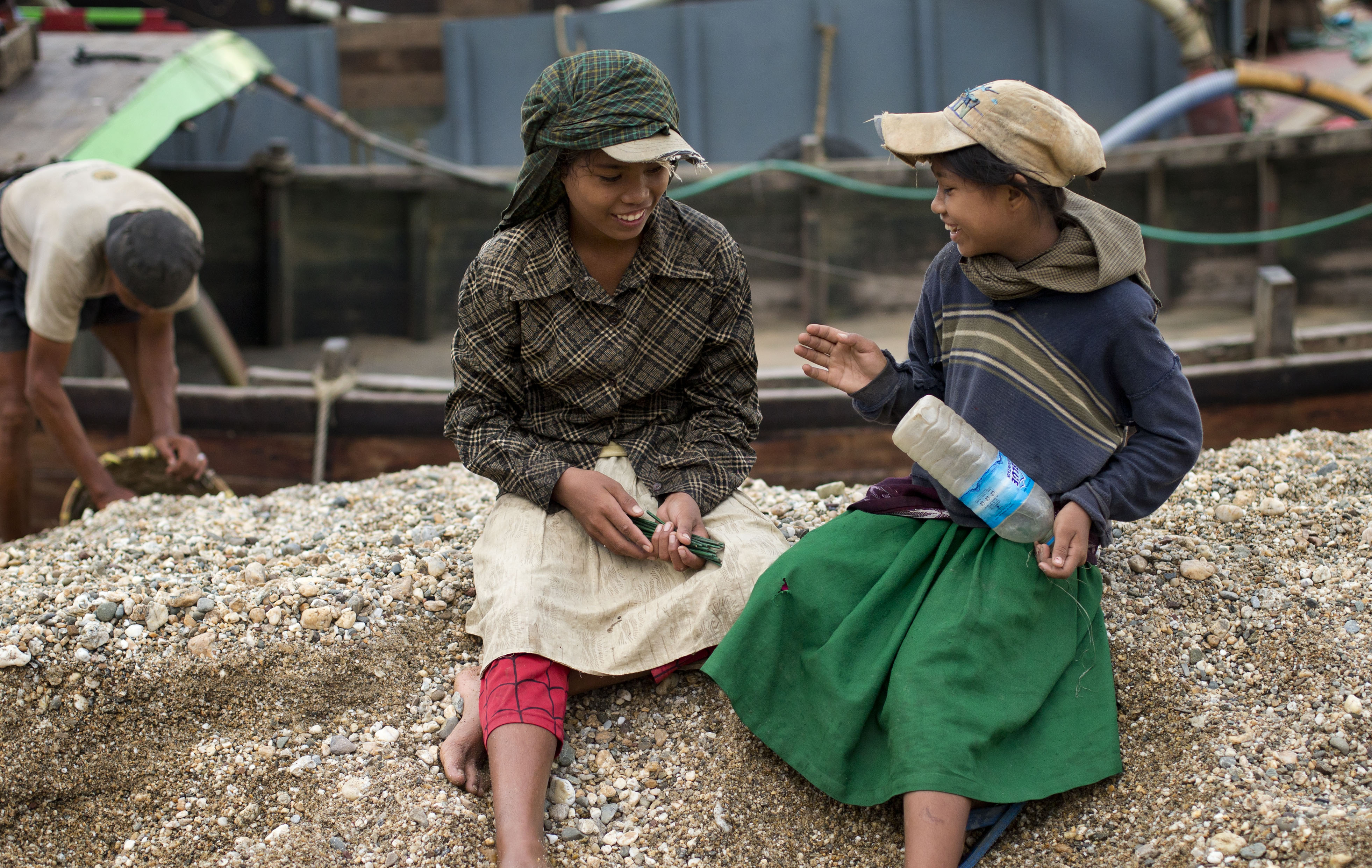 In this Nov. 22 2012 photo, Po Po Aung, left and Cho Cho Aung right count sticks-that reflects the tally of baskets of gravel they hulled in a riverside barge in Yangon, Myanmar. The sisters haul gravel for less than 4 cents for each 20 kilogram (44 pound) basket, earning money to pay for school fees. From India to Indonesia, Myanmar and the Philippines, overcrowded cities have become studies in extremes of deprivation and wealth. (AP Photo/Gemunu Amarasinghe) (AP)