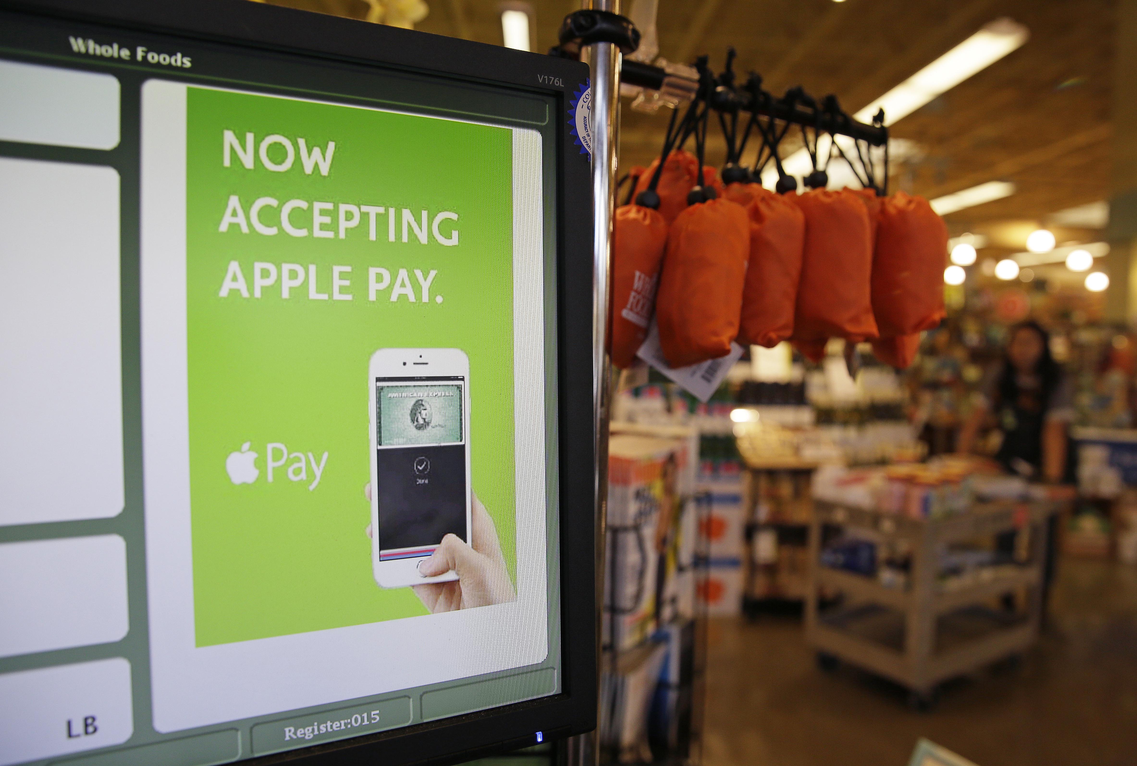 In this photo taken Friday, Oct. 17, 2014, a cash register terminal promotes usage of the new Apple Pay mobile payment system at a Whole Foods store in Cupertino, Calif. The new system launches on Monday. (AP Photo/Eric Risberg) (AP)