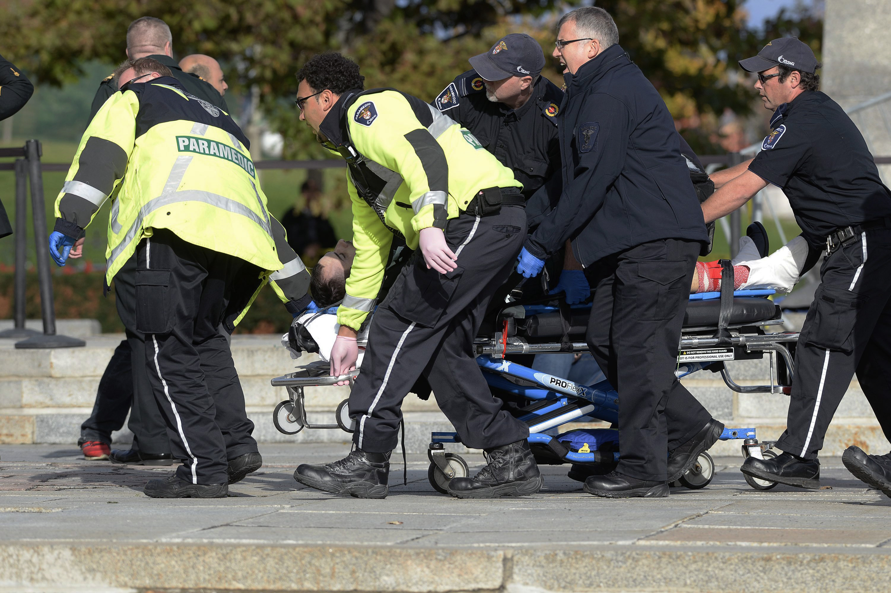 Paramedics and police pull a victim away from the Canadian War Memorial in Ottawa, Ontario, on Wednesday, Oct. 22, 2014. (AP Photo/The Canadian Press, Adrian Wyld) (AP)