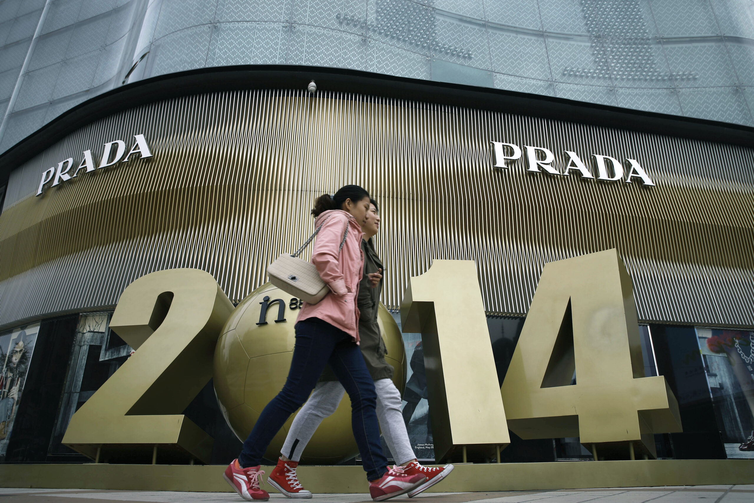 Chinese women walk past a luxury fashion boutique at a shopping mall in Beijing, China Tuesday, Oct. 21, 2014. China's economic growth waned to a five-year low of 7.3 percent last quarter, raising concerns of a spillover effect on the global economy but falling roughly in line with Chinese leaders' plans for a controlled slowdown. (AP Photo/Andy Wong) (Andy Wong)