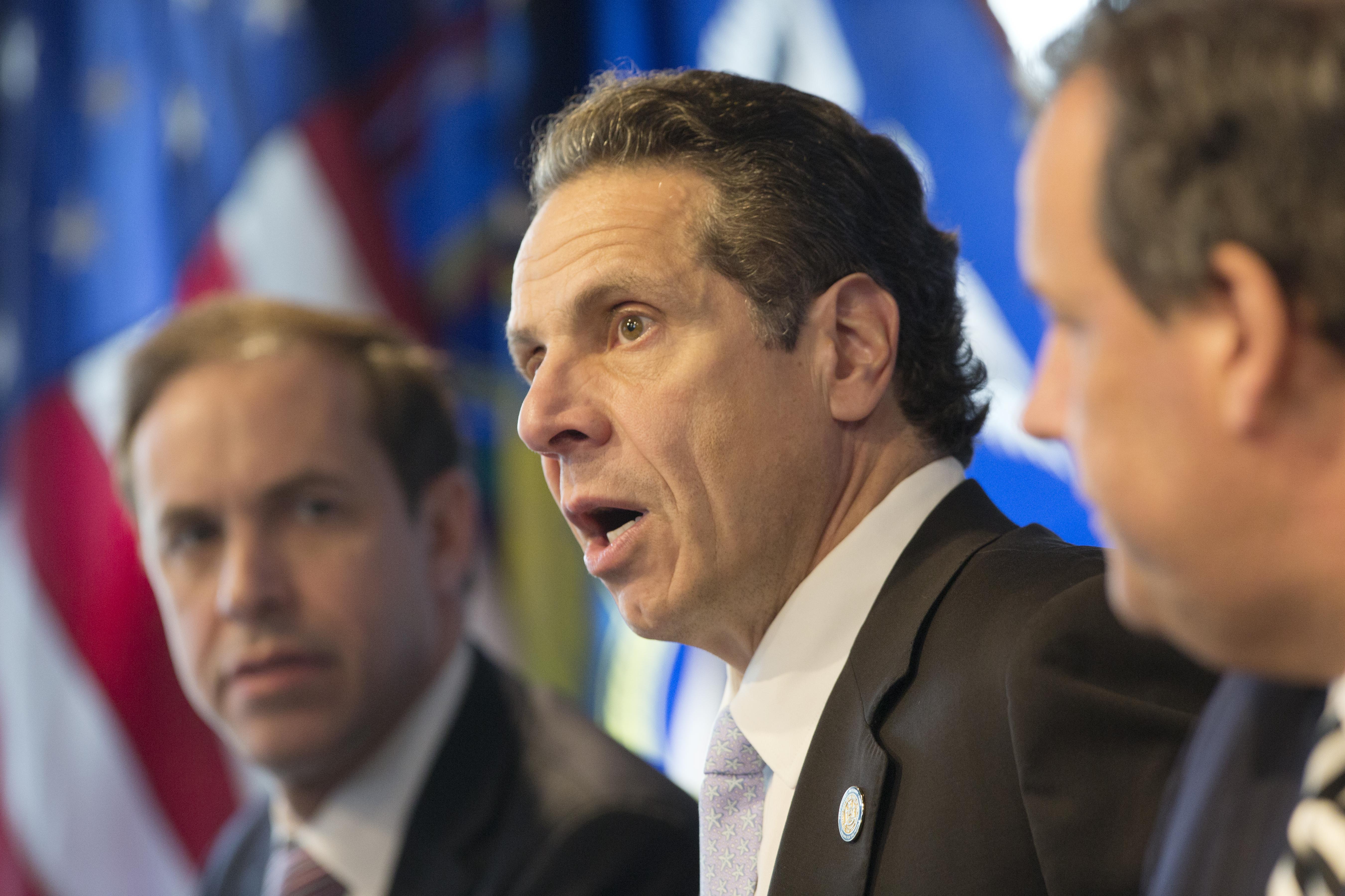 New York Governor Andrew Cuomo, center, speaks at a news conference, Friday, Oct. 24, 2014 in New York. At left is Dr. Howard Zucker, acting commissioner of the New York State Department of Health, and New Jersey Governor Chris Christie is at right. The governors announced a mandatory quarantine for people returning to the United States through airports in New York and New Jersey who are deemed "high risk." In the first application of the new set of standards, the states are quarantining a female healthcare worker returning from Africa who took care of Ebola patients. (AP Photo/Mark Lennihan) (AP)