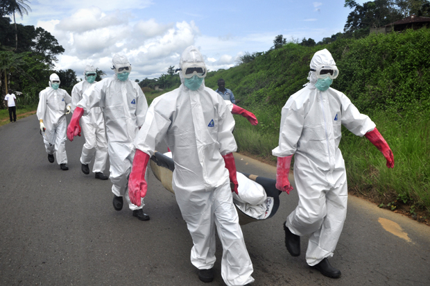 Burial team in protective gear carry a body of woman suspected to have died from Ebola virus in Monrovia, Liberia, Oct, 18, 2014. (AP/Abbas Dulleh)