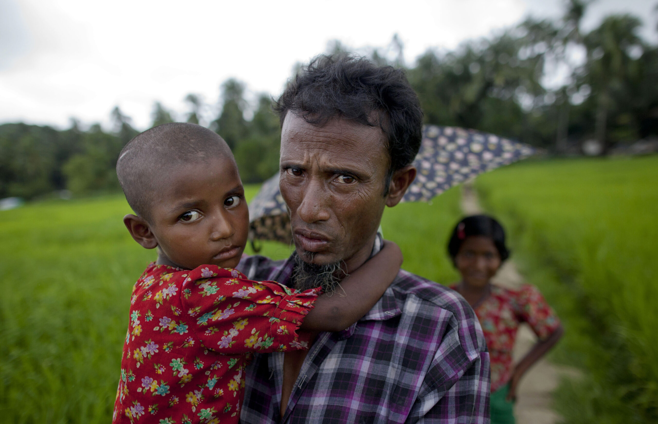 In this Sept. 17, 2013 photo, an ethnic Rohingya man, who was displaced following 2012 sectarian violence, walks carrying his daughter at Nga Chaung refugee Camp in Pauktaw, Rakhine state, Myanmar. Authorities sealed off villages for months in Myanmar's only Muslim-majority region and in some cases beat and arrested people who refused to register with immigration officials, residents and activists say, in what may be the most aggressive effort yet to compel Rohingya to identify themselves as illegal migrants from neighboring Bangladesh. (AP Photo/Gemunu Amarasinghe) (Gemunu Amarasinghe)