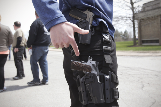 A gun rights supporter openly carries two pistols strapped to his leg during a rally in support of the Michigan Open Carry gun law in Romulus, Michigan April 27, 2014. (Reuters/Rebecca Cook)
