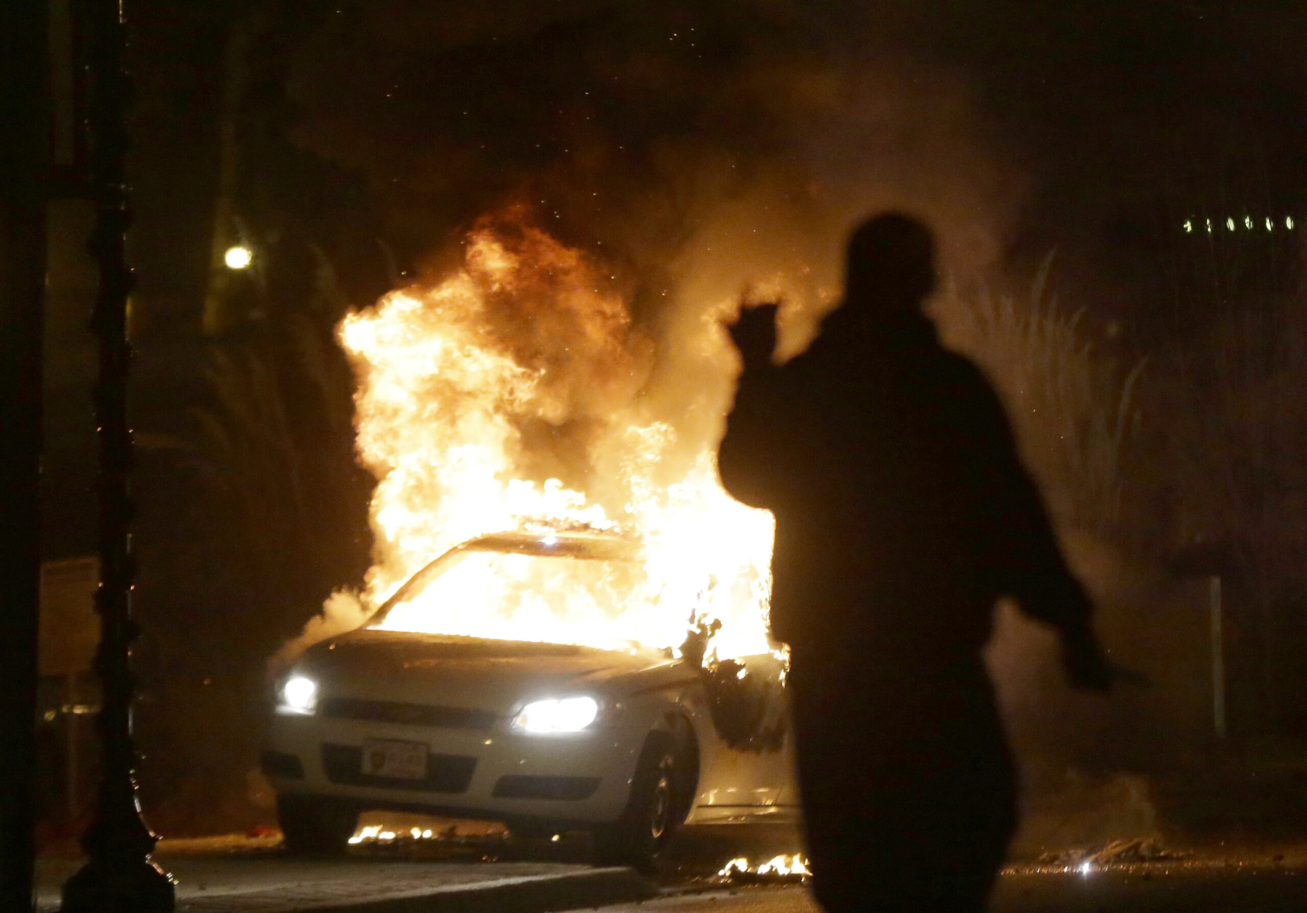 A police car is set on fire after a group of protesters vandalize the vehicle after the announcement of the grand jury decision Monday, Nov. 24, 2014, in Ferguson, Mo. A grand jury has decided not to indict Ferguson police officer Darren Wilson in the death of Michael Brown, the unarmed, black 18-year-old whose fatal shooting sparked sometimes violent protests. (AP Photo/Charlie Riedel) (AP)