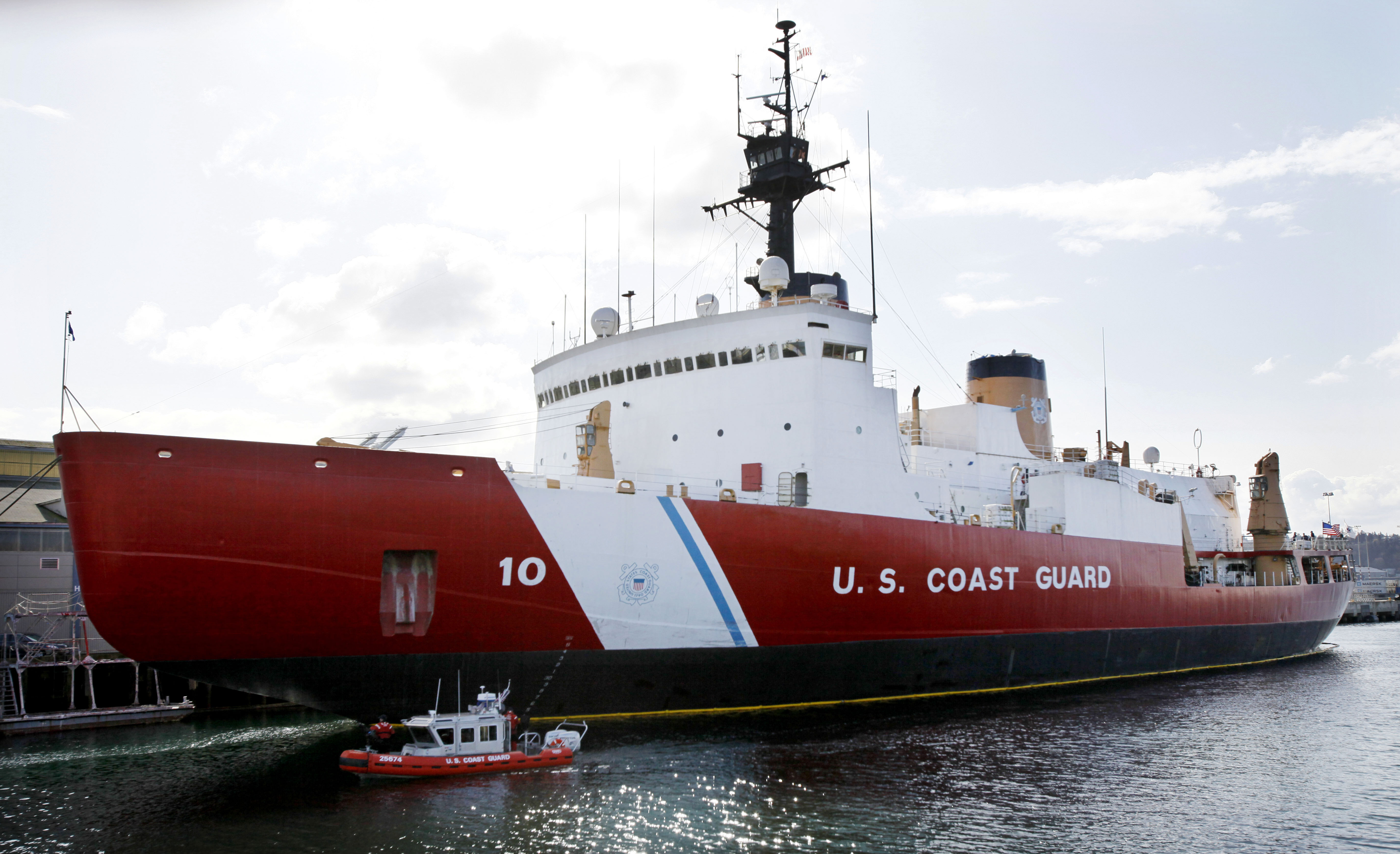 FILE - In this March 10, 2010, file photo, a 25-foot harbor patrol boat passes by the 399-foot U.S. Coast Guard icebreaker Polar Star as it sits moored at a dock in Seattle. The United States' last vessel capable of breaking through the heaviest ice of the Arctic Circle, and resupplying the U.S. polar research station there, is scheduled to leave San Francisco Bay on Tuesday, Nov. 11, 2014. While Russia and China have dozens of icebreakers, opposition in Congress to funding means the U.S. has just one heavy-duty one, already a decade past its decommissioning date. (AP Photo/Elaine Thompson, File) (AP)