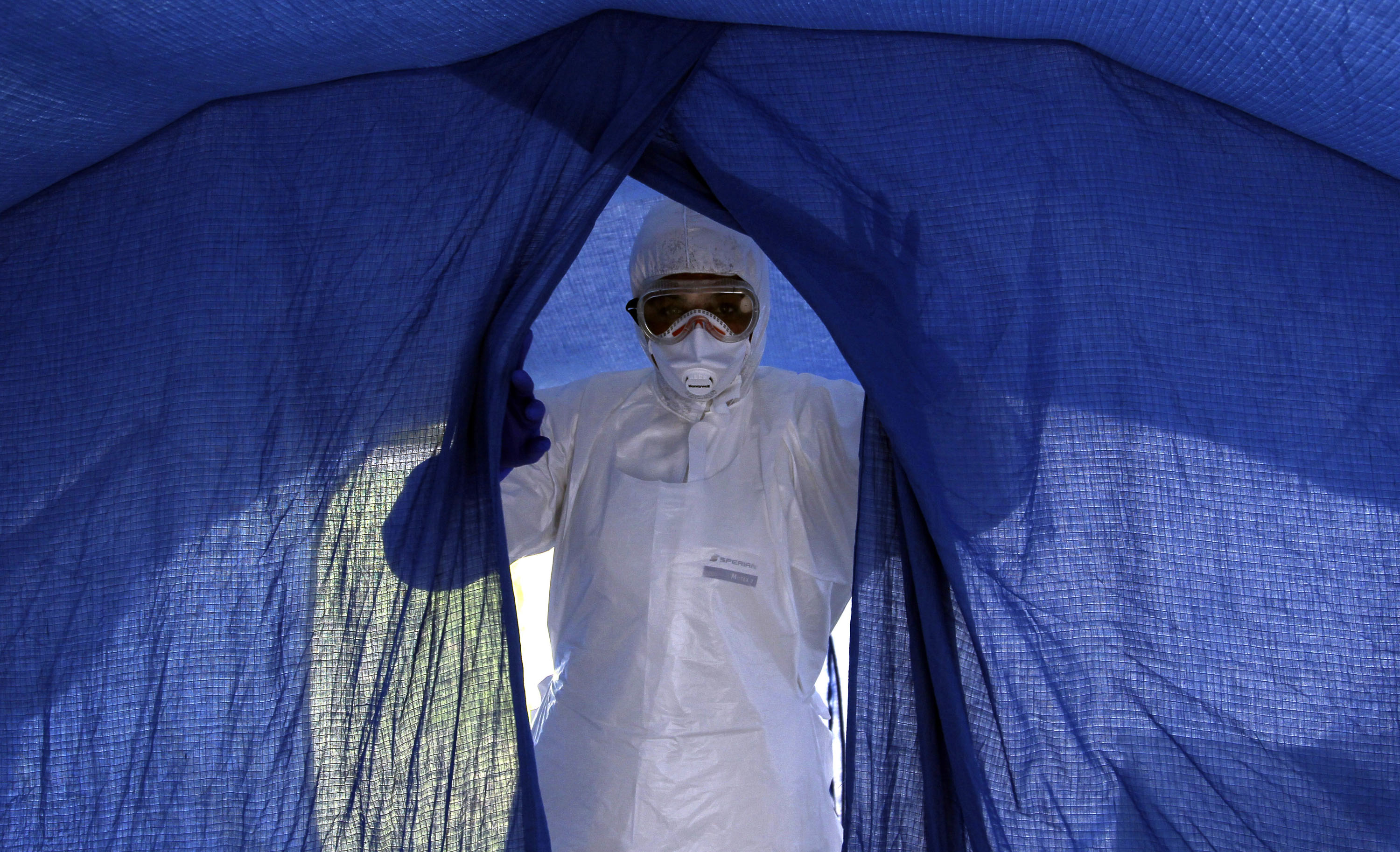 In this file photo taken on Sept. 24, 2014, nurse Dalila Martinez, trainer of the Cuban medical team to travel to Sierra Leone, enters a tent during a practice drill at a training camp, in Havana, Cuba. (AP Photo/Ladyrene Perez, Cubadebate, File)