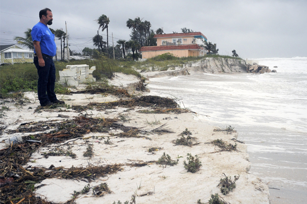 Tim Change, from the Bradenton Beach Public Works Dept., inspects beach erosion as a storm surge and high winds associated with Tropical Storm Debby batter Bradenton Beach, Fla., June 25, 2012. (Reuters)
