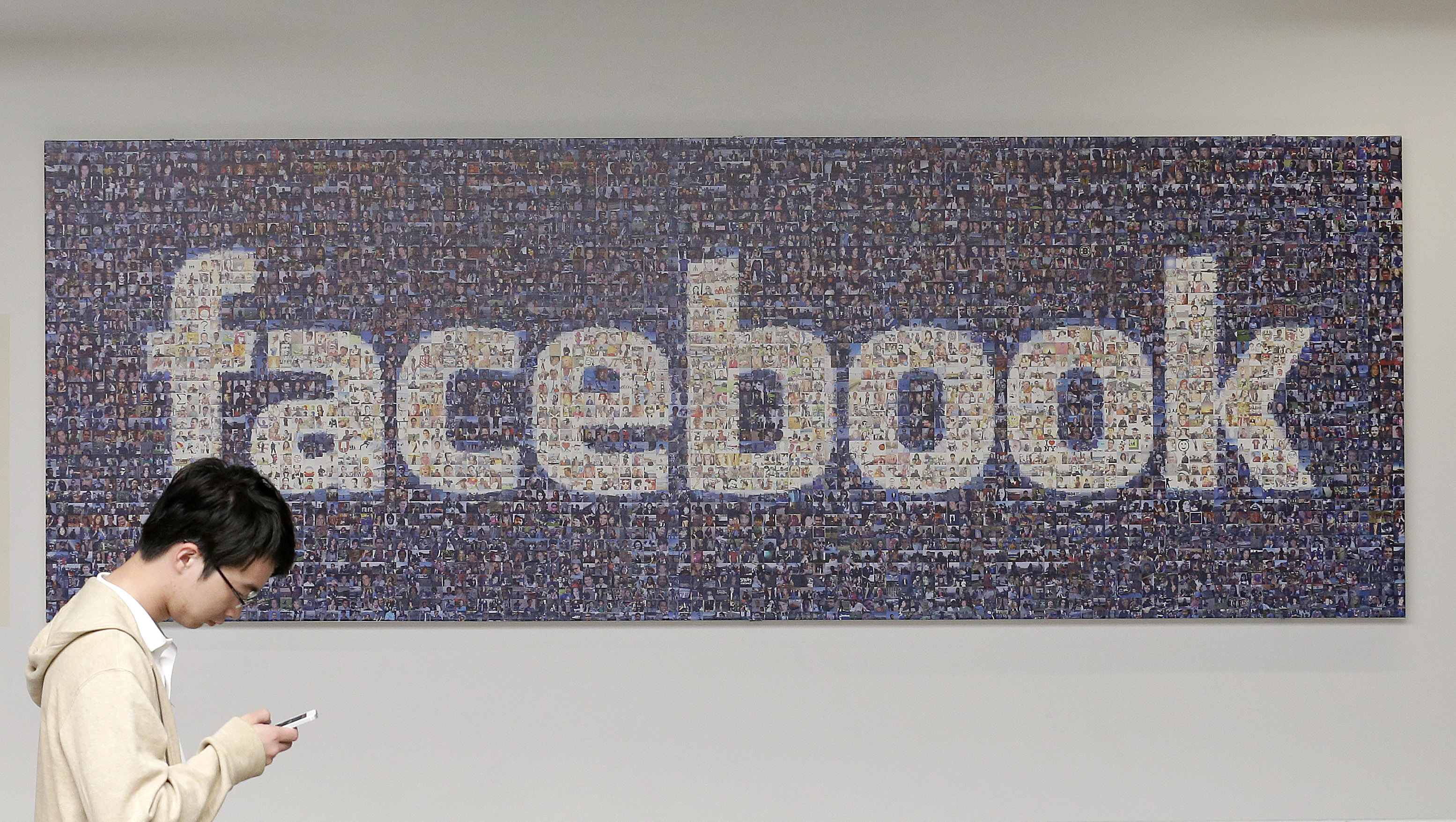 A man walks past a sign in an office on the Facebook campus in Menlo Park, Calif. (AP/Jeff Chiu)