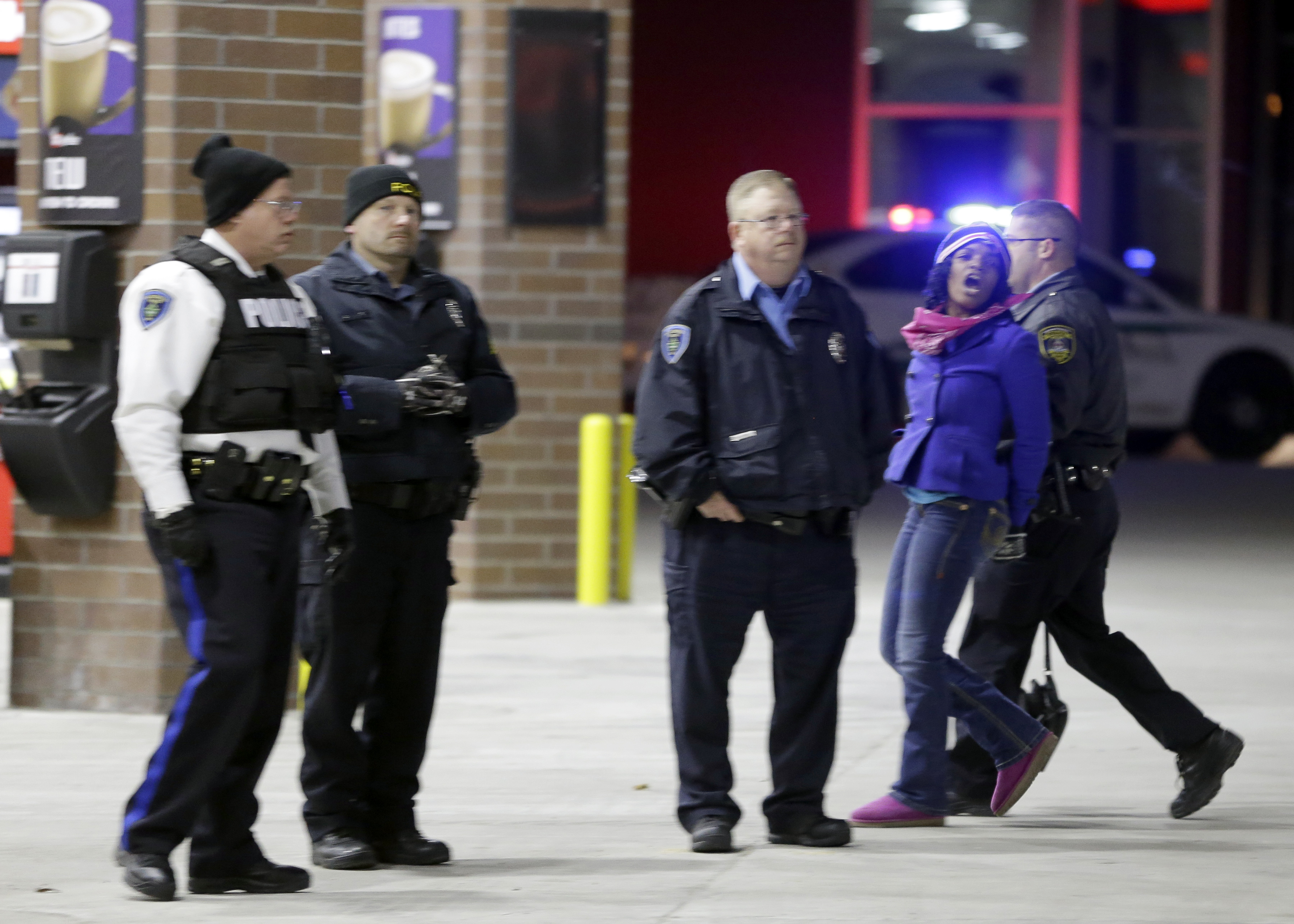 Police take a person into custody Tuesday, Nov. 25, 2014, in Brentwood, Mo. Missouri's governor ordered hundreds more state militia into Ferguson on Tuesday, after a night of protests and rioting over a grand jury's decision not to indict police officer Darren Wilson in the fatal shooting of Michael Brown, a case that has inflamed racial tensions in the U.S. (AP Photo/Jeff Roberson) (AP)